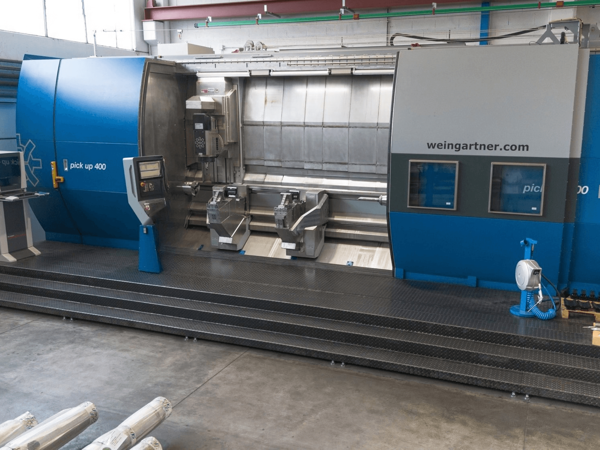 Centro di tornitura e fresatura Weingartner Pick Up 400, vista frontale. Dotato di doppia postazione di lavoro e pannello di controllo, in ambiente industriale.