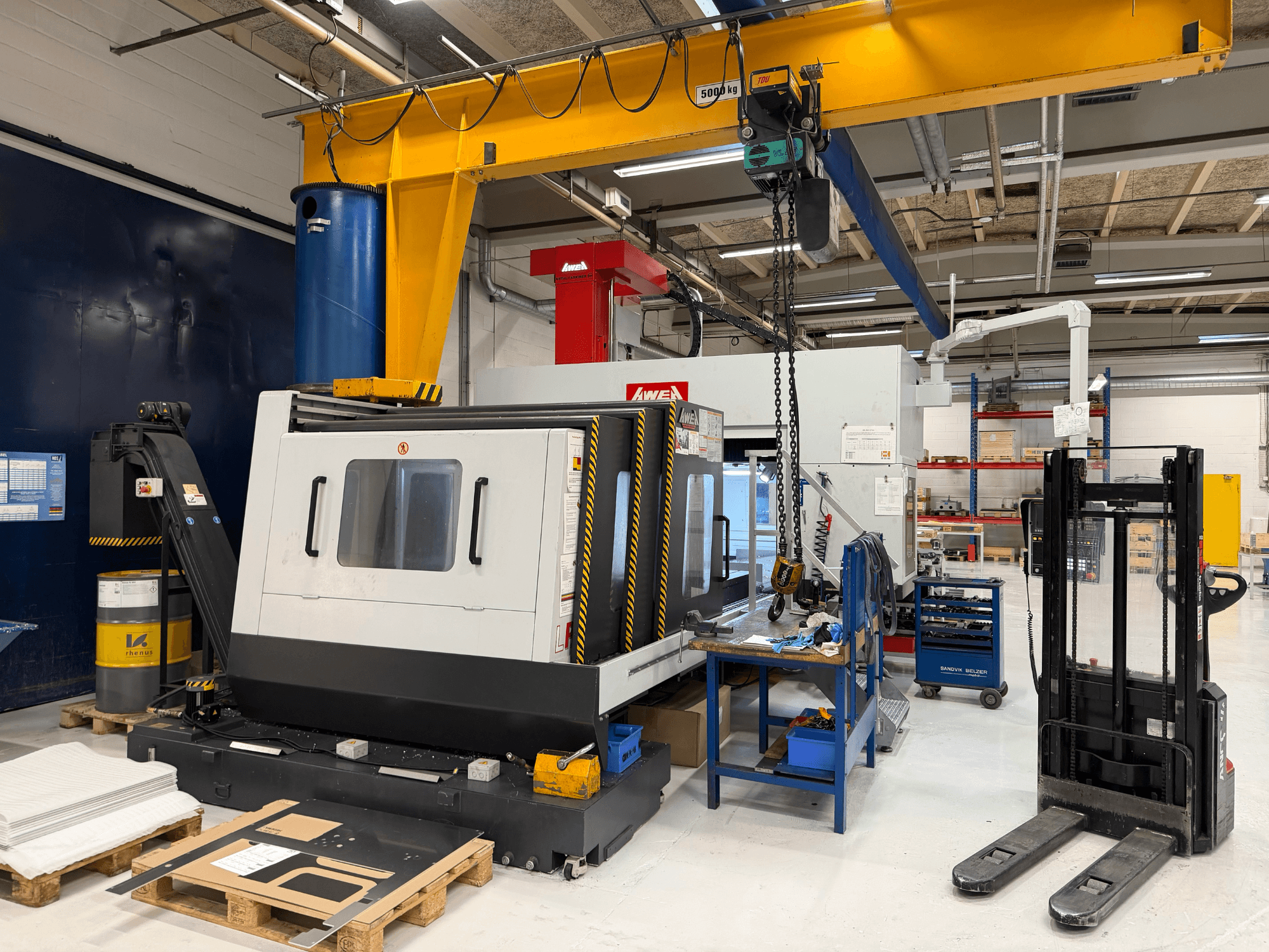 Fresatrice a portale AWEA LP3016YF, vista frontale, con utensili, vasca blu e area di lavoro sullo sfondo.