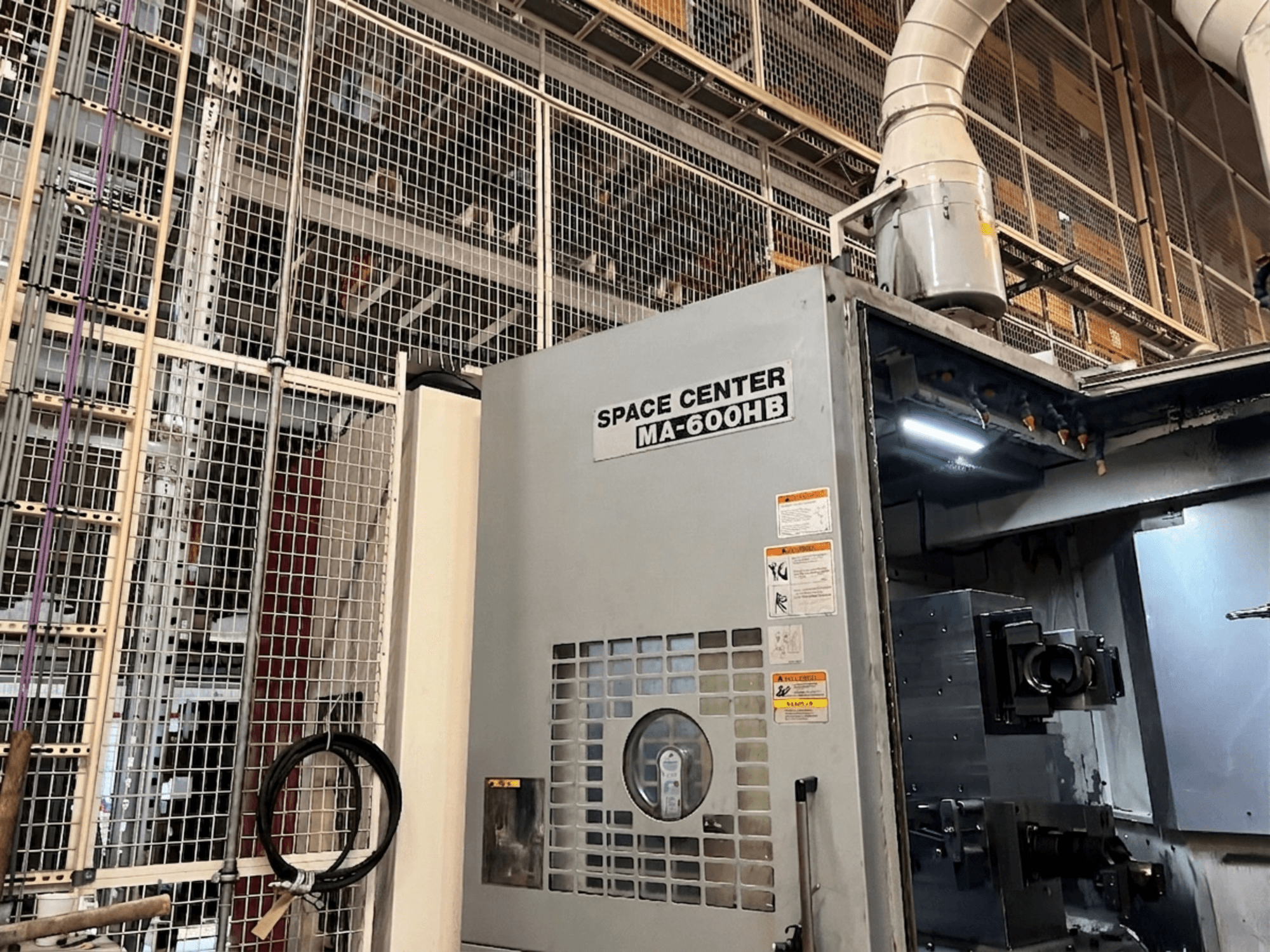 Centro di lavoro orizzontale Okuma MA-600HB, vista frontale, con pannello operativo e ugelli del refrigerante visibili.