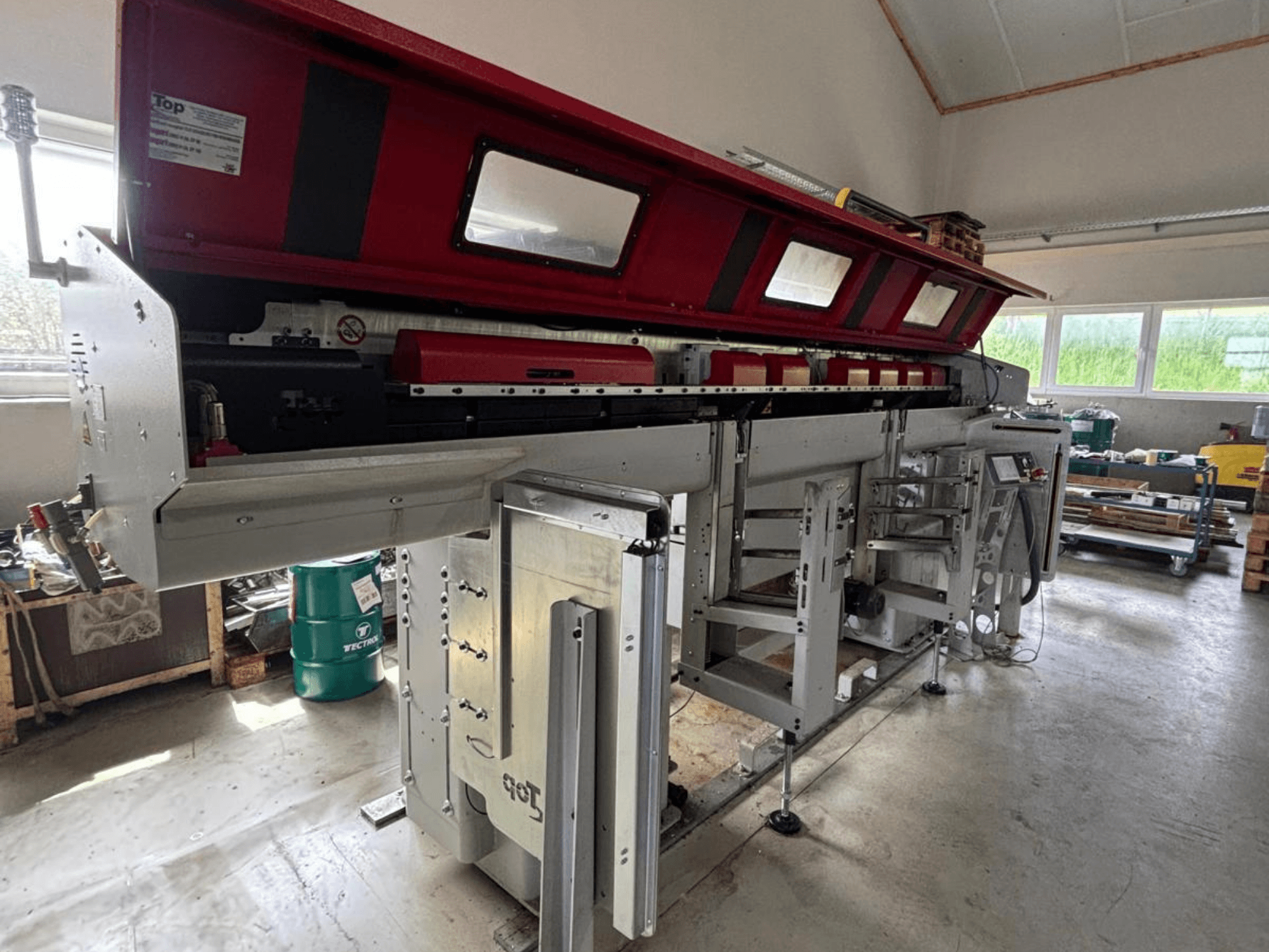 TOP Automazioni Top Loader ETL 10-75 visto di profilo, caratterizzato da una sezione superiore rossa e da complessi componenti meccanici.