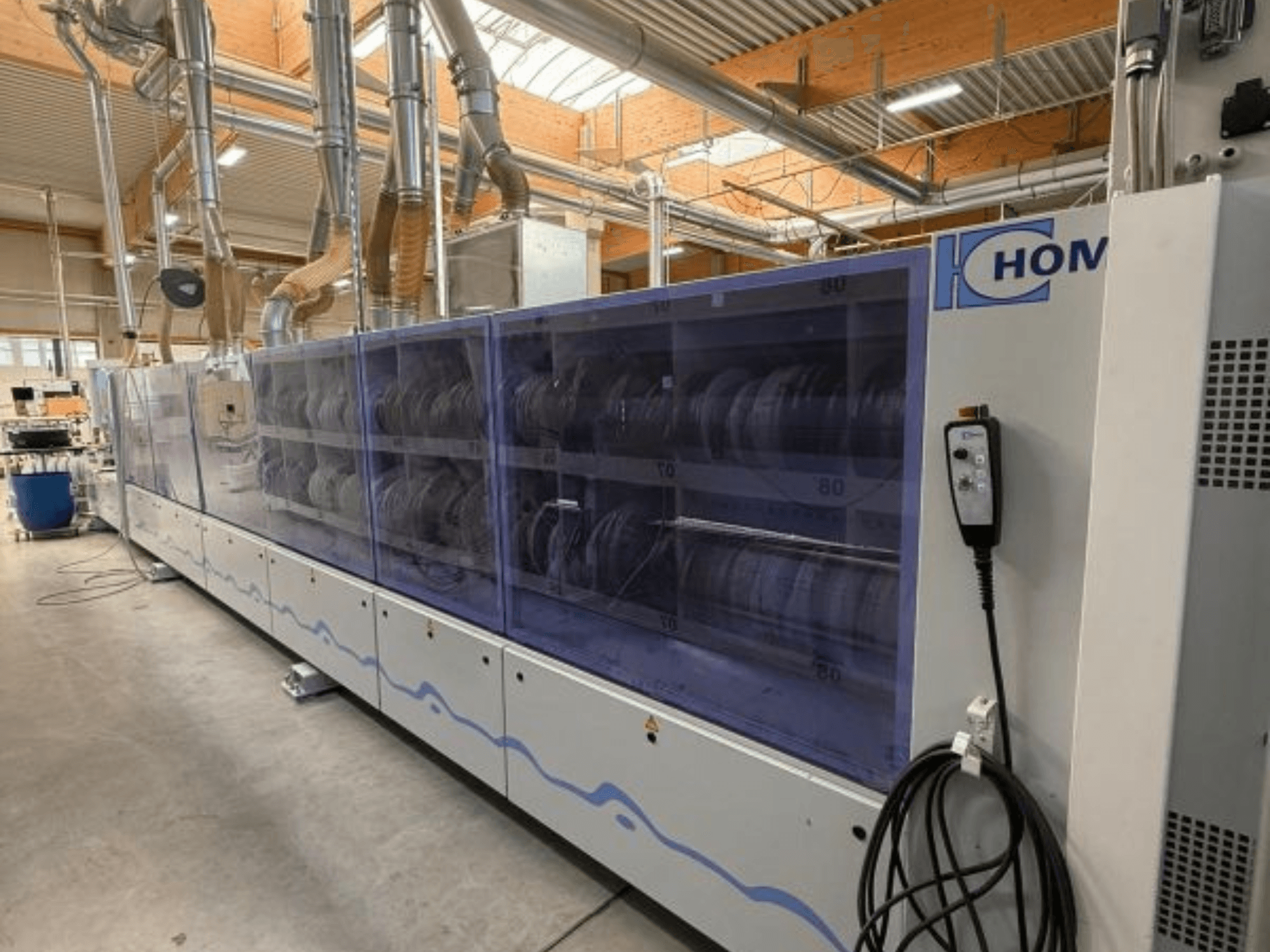 Lavatrice industriale HOM, vista frontale, con pannello trasparente per la visualizzazione delle stoviglie; pannello di controllo con pulsanti laterali.