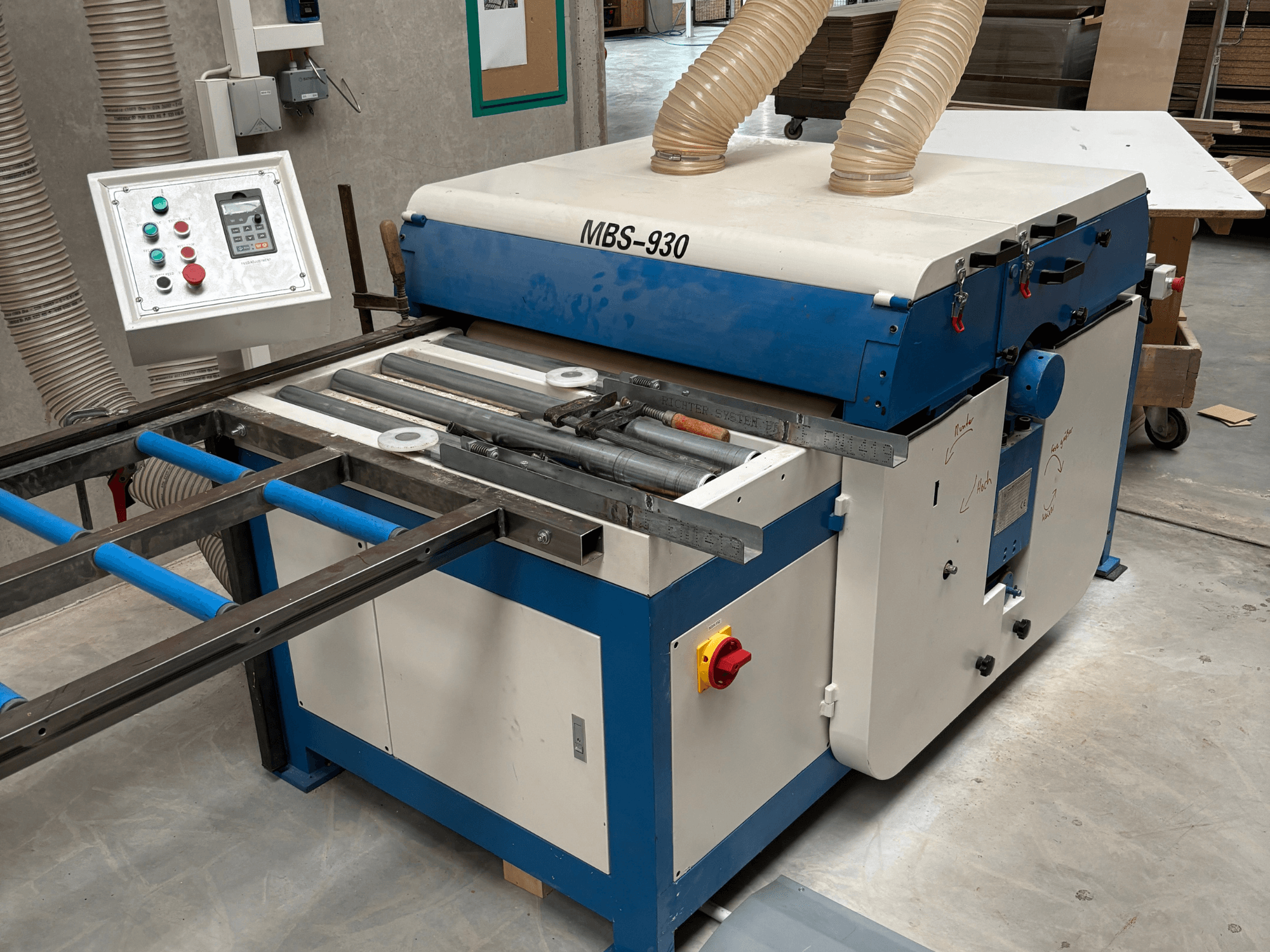 Macchina per la lavorazione del legno MBS-930 con pannello di controllo e rulli, vista di lato, con tubi di aspirazione della polvere.