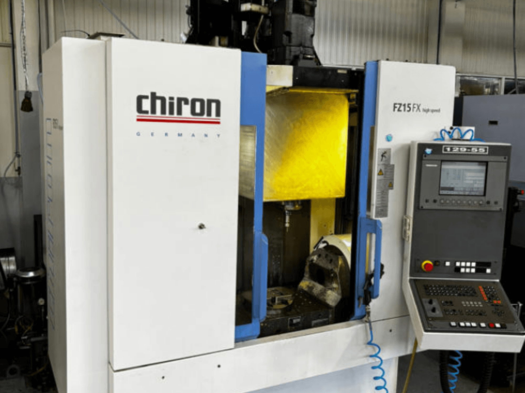 Centro di lavorazione verticale CHIRON FZ 15FX, vista frontale, con pannello di controllo e area di lavorazione visibile con gli utensili.