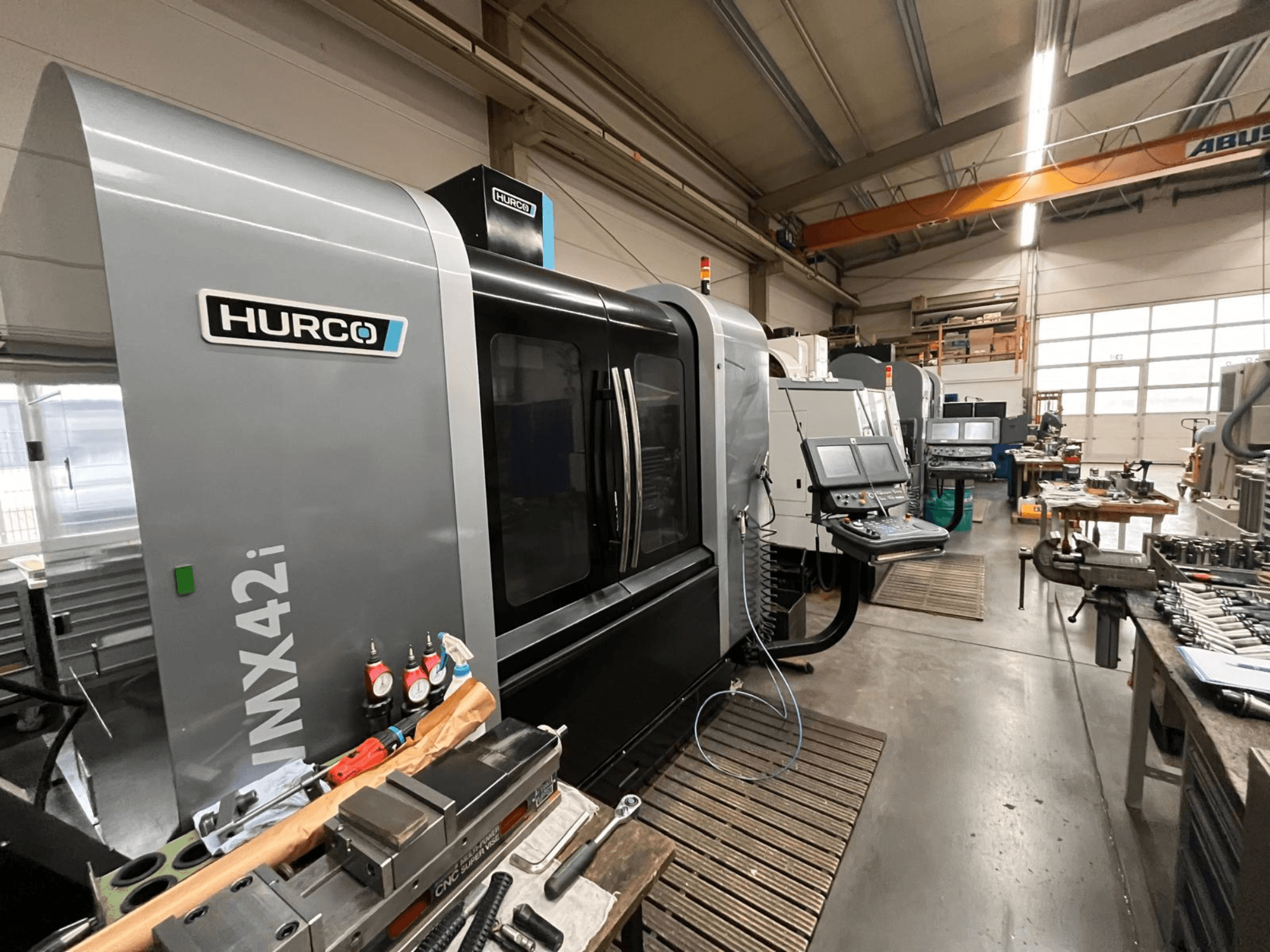 Macchina CNC Hurco VMX42i in un'officina, vista frontale. Pannello di controllo, corpo grigio e ambiente industriale.