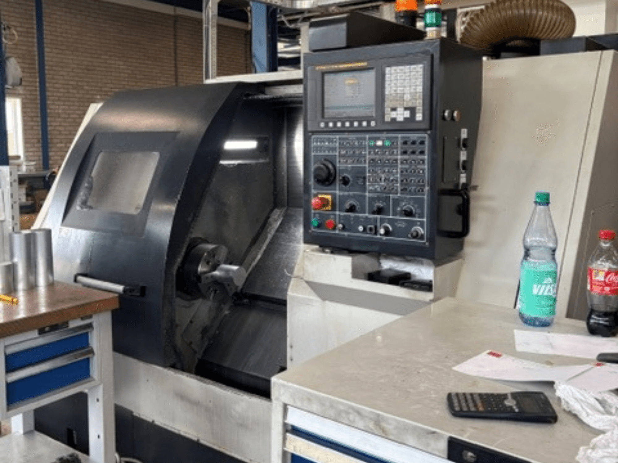 Tornio orizzontale Leadwell T-7, vista frontale, con pannello di controllo, pezzo sul portapezzo e dettagli dell'area di lavoro ben visibili.