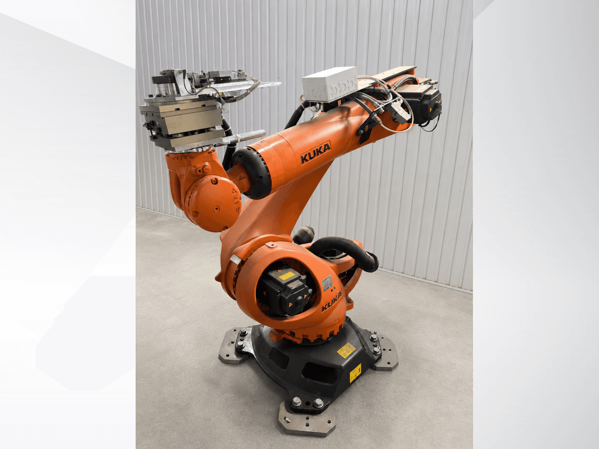 Braccio robotico aggiuntivo KUKA KR 90 R3100 di colore arancione, vista laterale, che mostra le articolazioni, il controller e l'attrezzatura montata sull'effettore terminale.