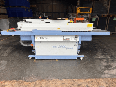 Hebrock Top 2000 Plus, vista frontale; macchina elettrica industriale con pannello di controllo, ruote per la mobilità ed etichette di sicurezza visibili.