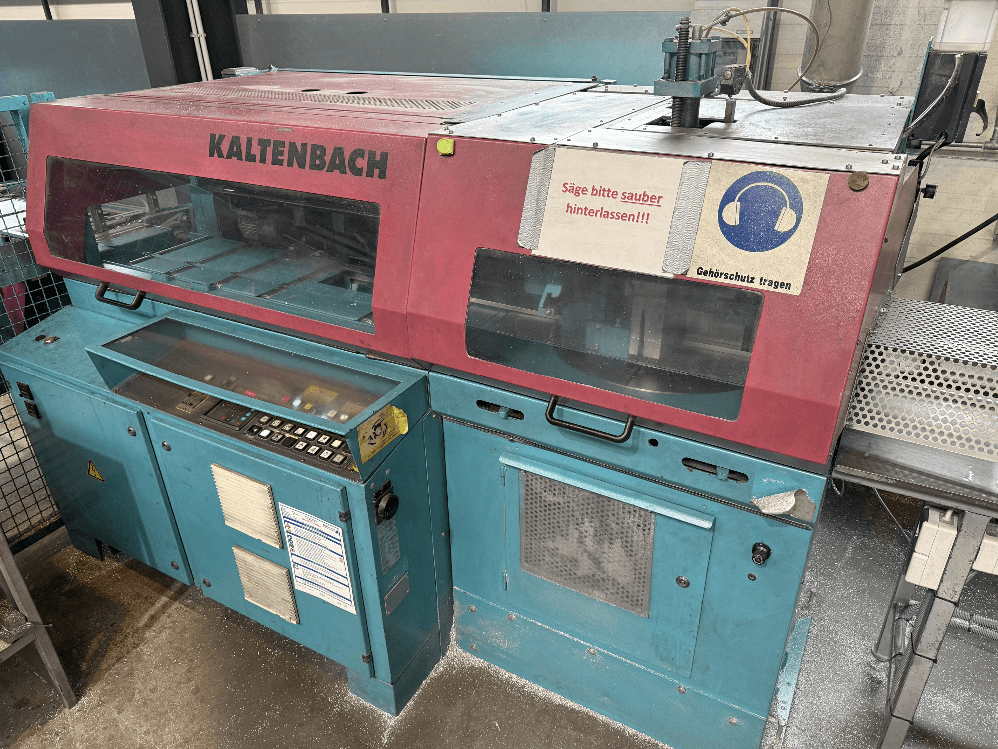 Macchina da taglio industriale KALTENBACH, vista frontale, con pannello di controllo e segnale di sicurezza per la protezione dell'udito.