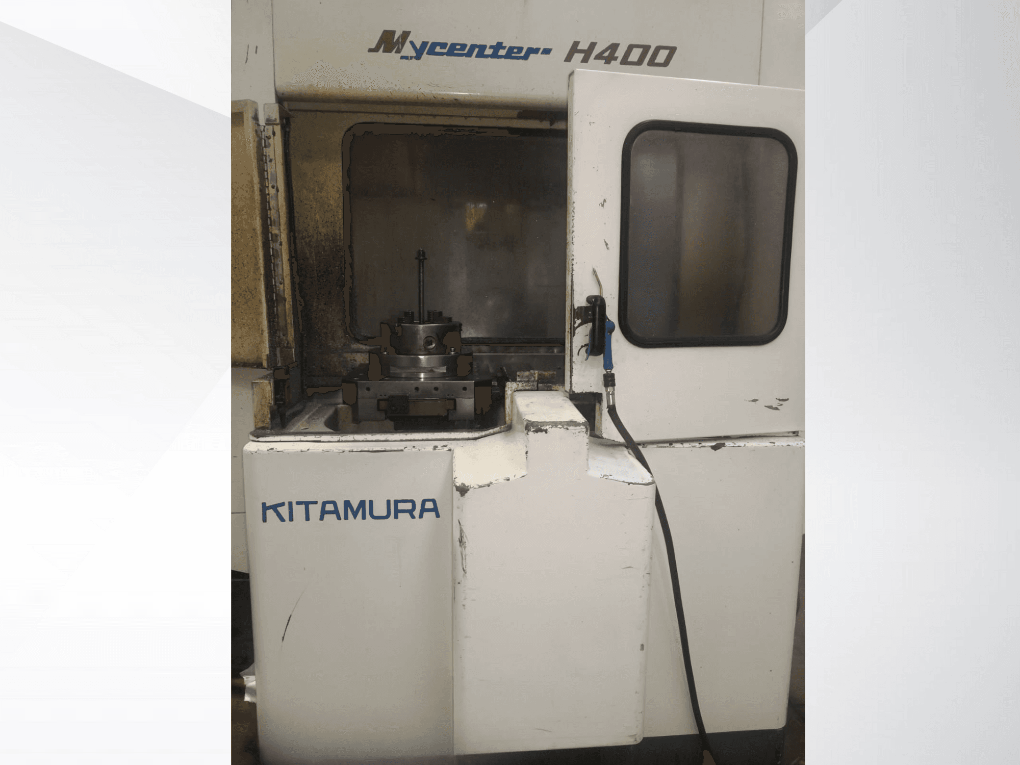 Macchina CNC Kitamura Mycenter H400, vista frontale, con area di lavoro e pannello di controllo visibili, con segni di utilizzo.