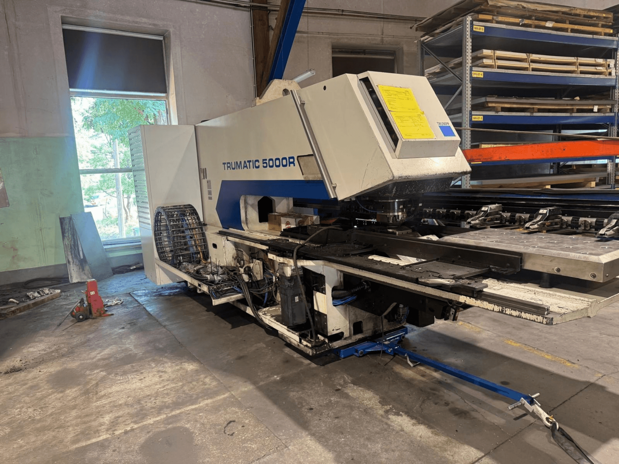 Punzonatrice CNC TRUMPF TRUMATIC 5000R in un'officina, vista frontale che mostra i comandi e l'area di punzonatura.