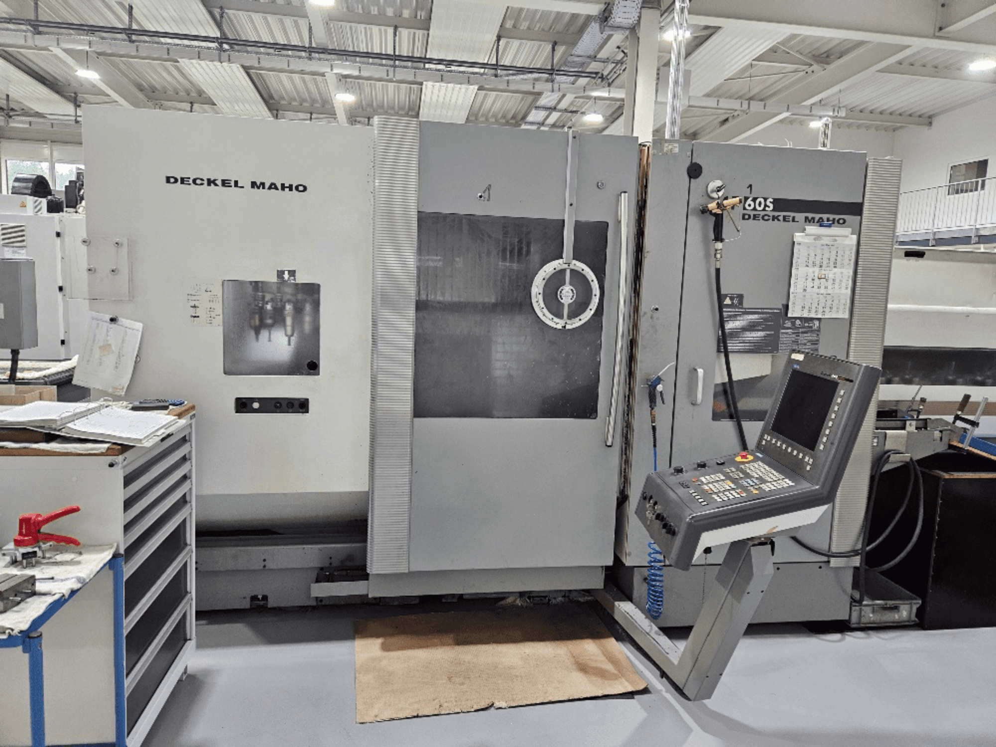 Macchina CNC Deckel Maho 605 con pannello di controllo e funzioni operative, vista frontalmente in un'officina.