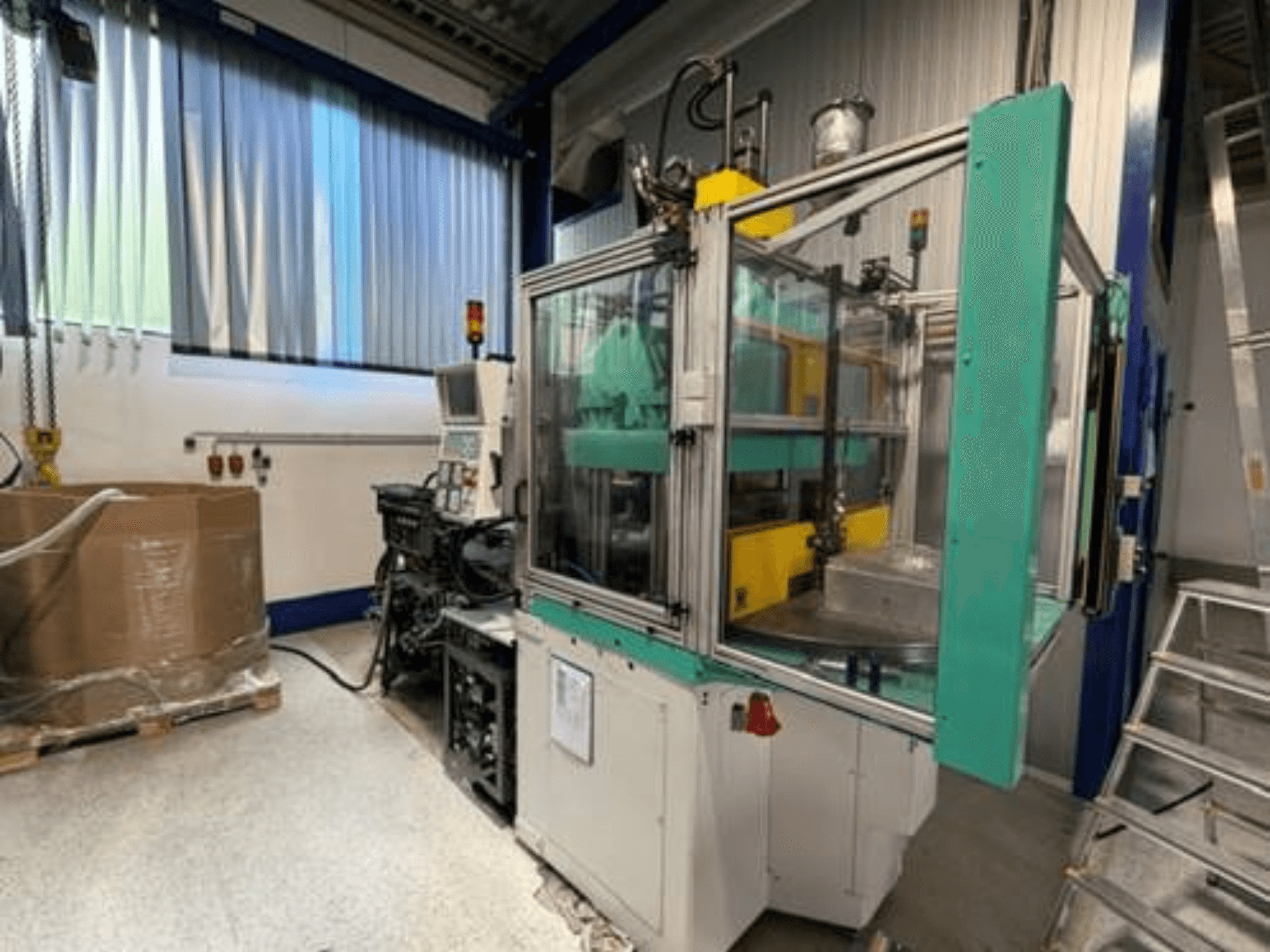 Macchina per stampaggio a iniezione verticale Arburg 1200 TS 800-60-350, vista laterale, con pannello di controllo e cabina di sicurezza trasparente.