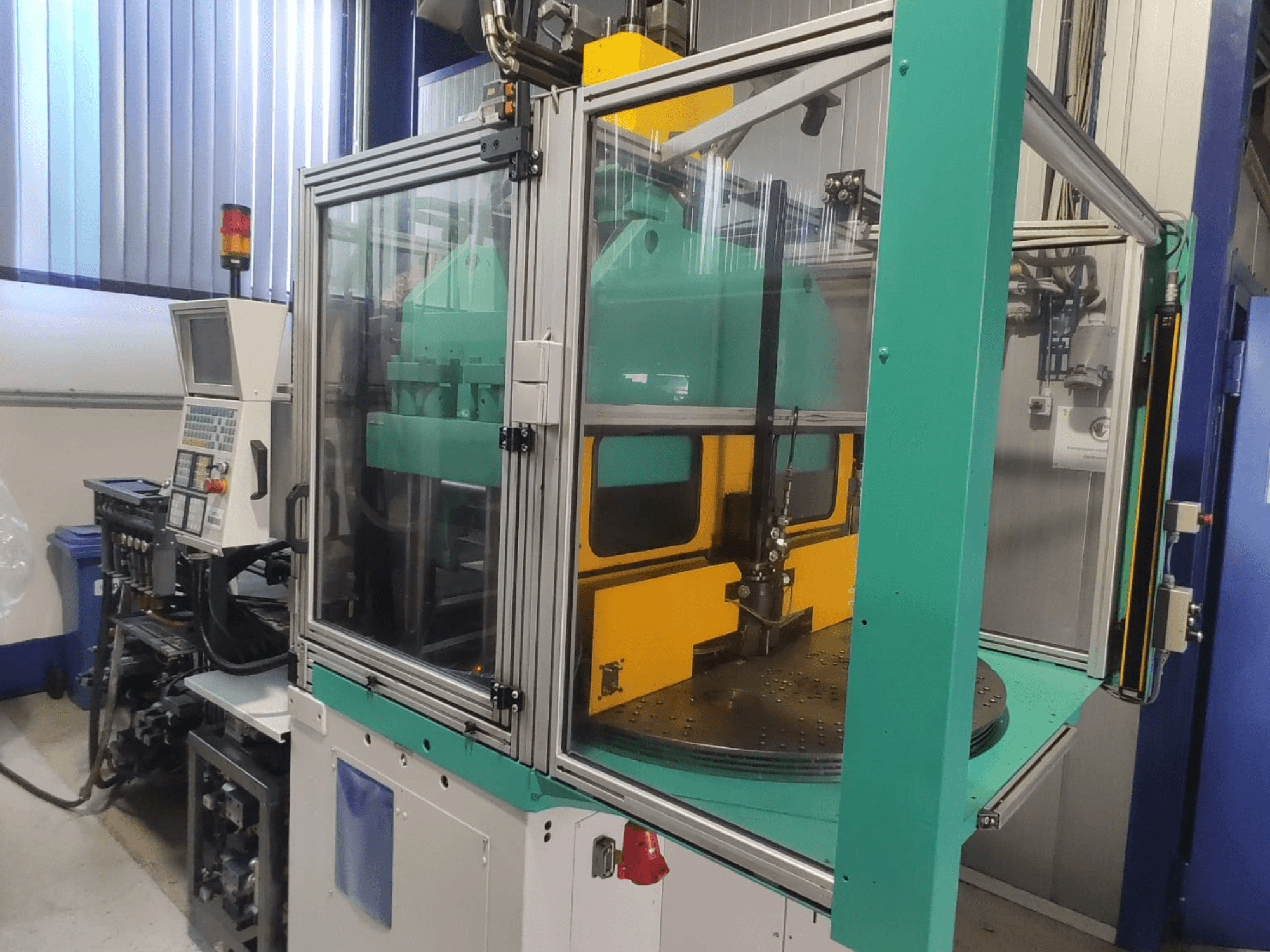 Macchina per stampaggio a iniezione verticale Arburg 1200 TS 800-60-350, vista frontale che mostra il pannello di controllo e la cabina di sicurezza.