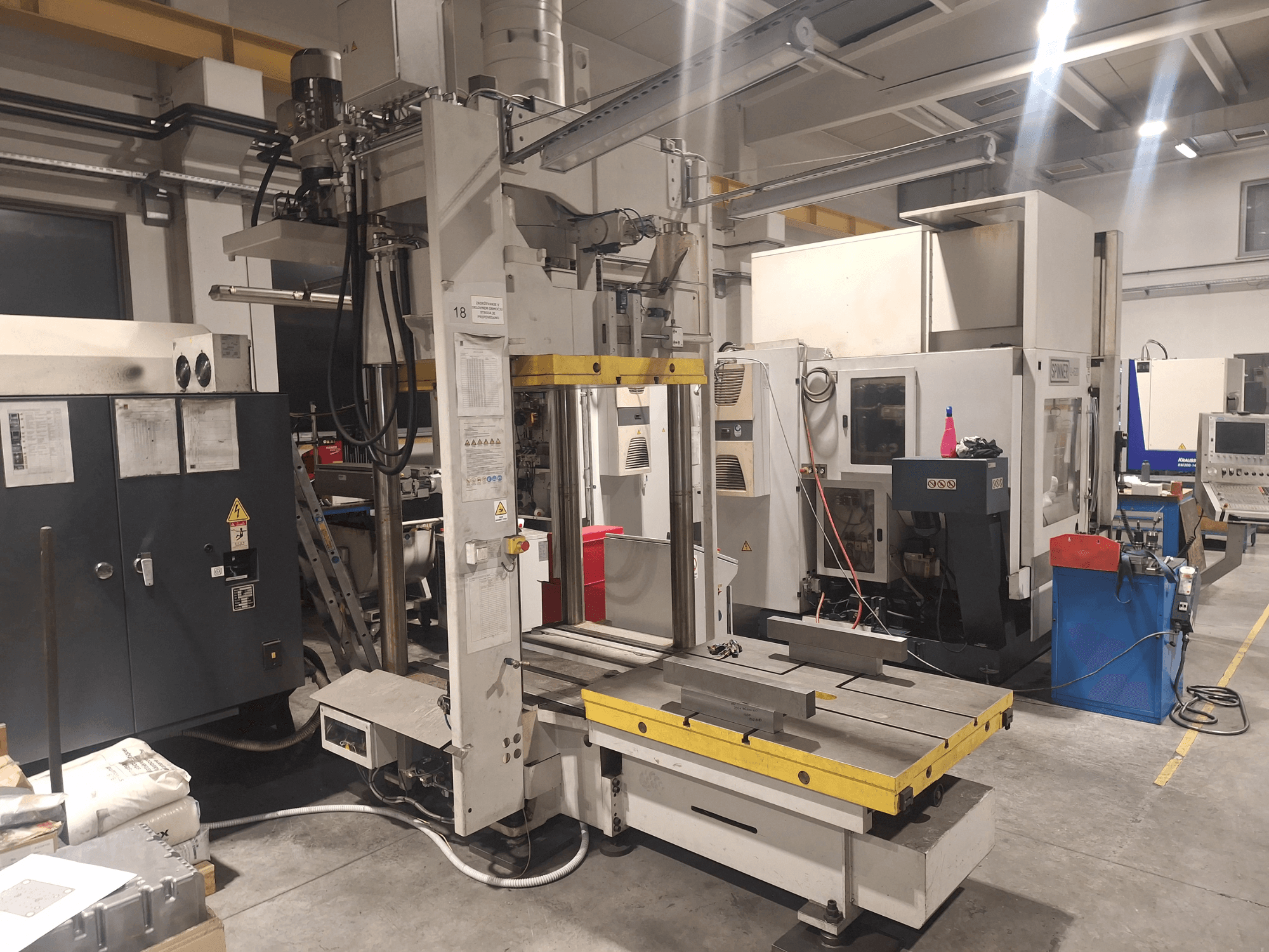 Fresatrice orizzontale di Synergic, vista frontale; dispone di un ampio tavolo e di vari pannelli di controllo, in un ambiente di officina.