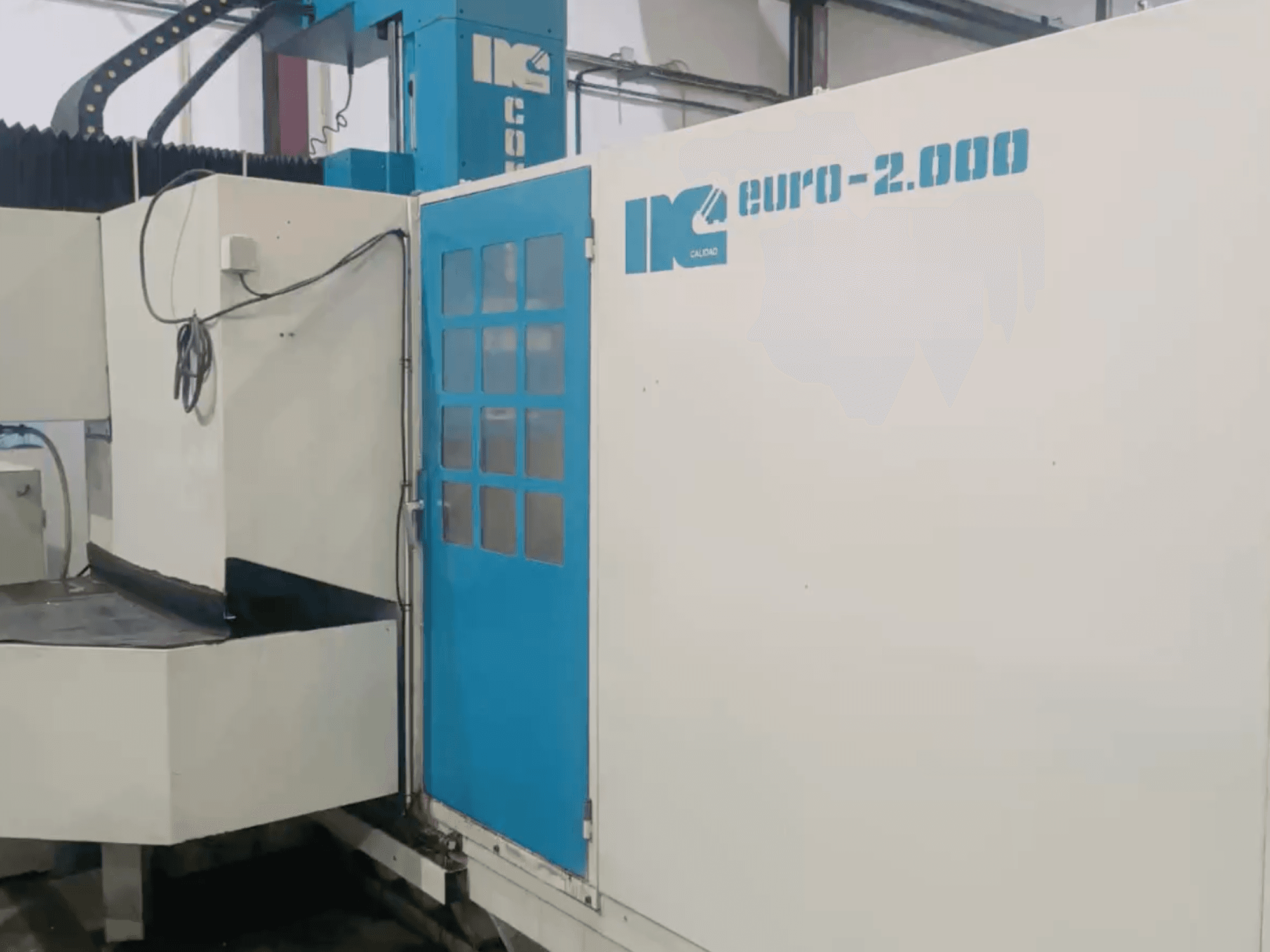 Macchina industriale di IK, modello Euro-2000, vista frontalmente, con ampio banco di fresatura e pannello di controllo.