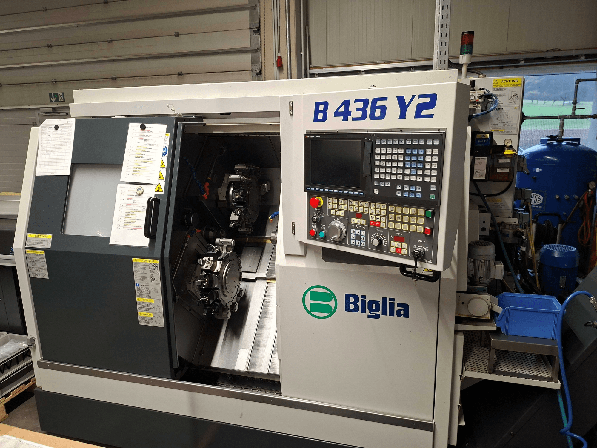 Tornio CNC Biglia B 436 Y2 in vista laterale, con doppio mandrino e pannello di controllo con pulsanti e display per le operazioni.