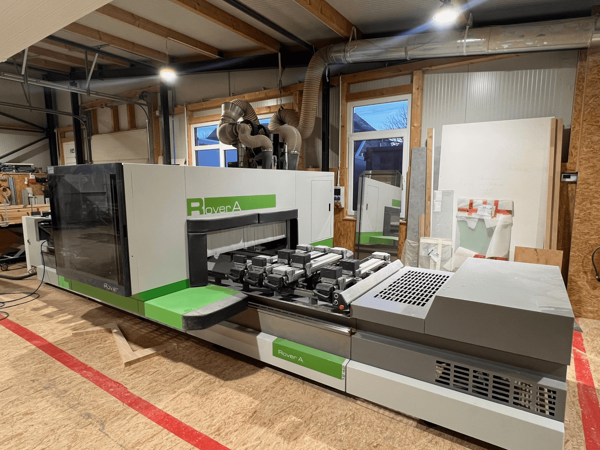 Centro di lavorazione del legno BIESSE Rover A 1242 CNC, vista frontale che mostra il pannello di controllo e l'area di taglio in un'officina.