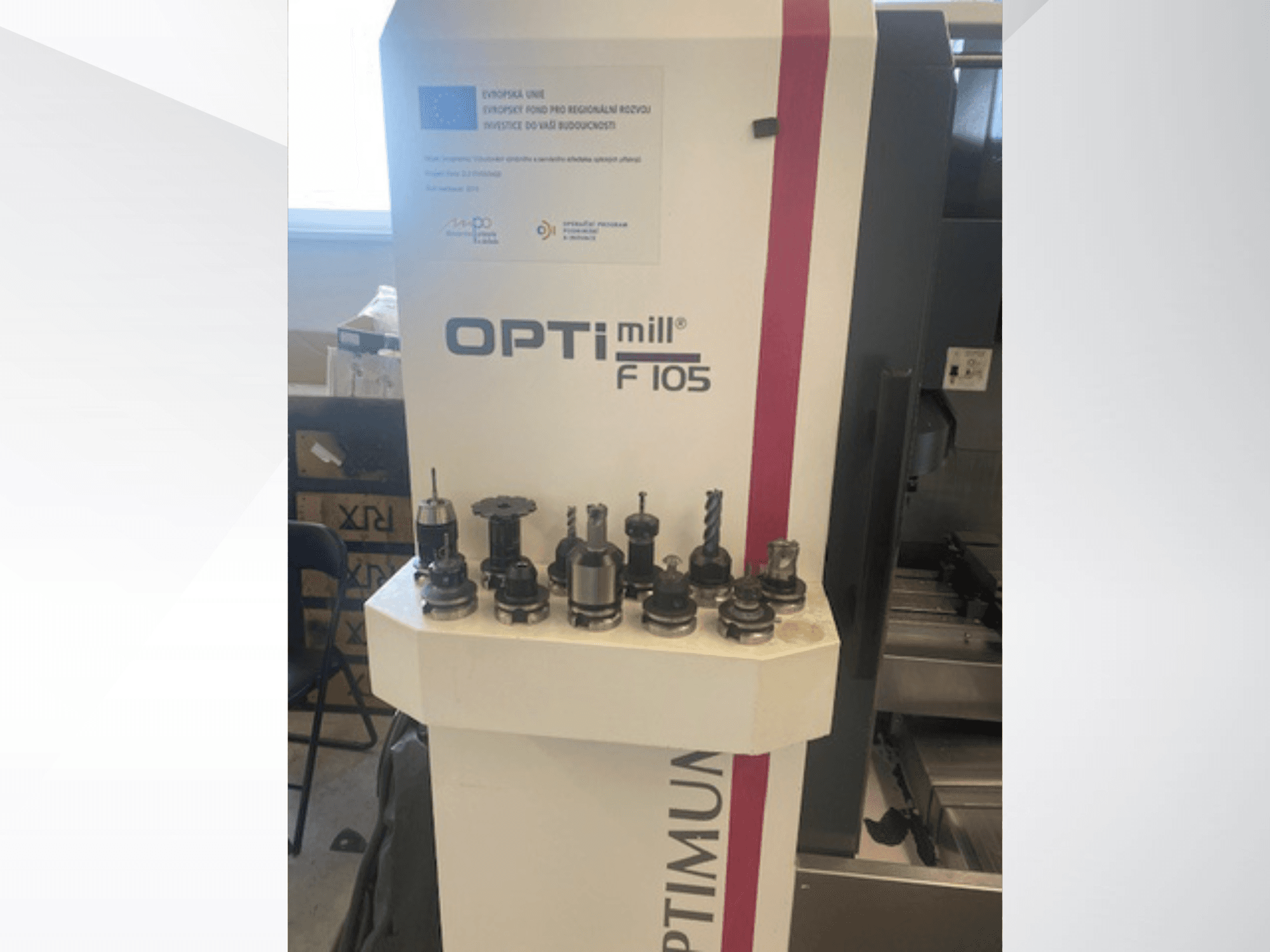 Vista frontale del centro di lavorazione verticale Optimum Optimill F105 con vari utensili montati visibili sul lato.