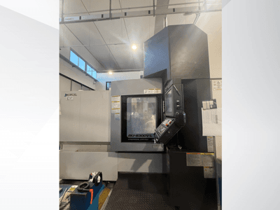 Macchina CNC Okuma MU-6300V-L vista dal davanti, con il pannello di controllo e le etichette di sicurezza.