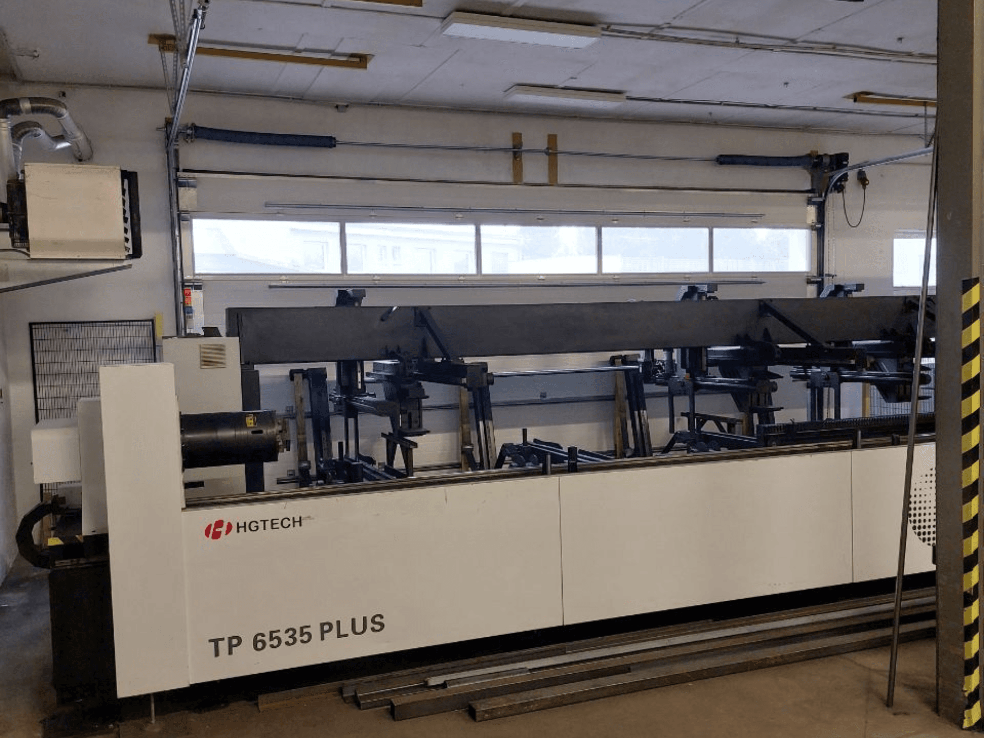 HGTECH TP 6535 PLUS, vista frontale di una grande macchina industriale a bracci multipli per la lavorazione di precisione, ambientata in un'officina.