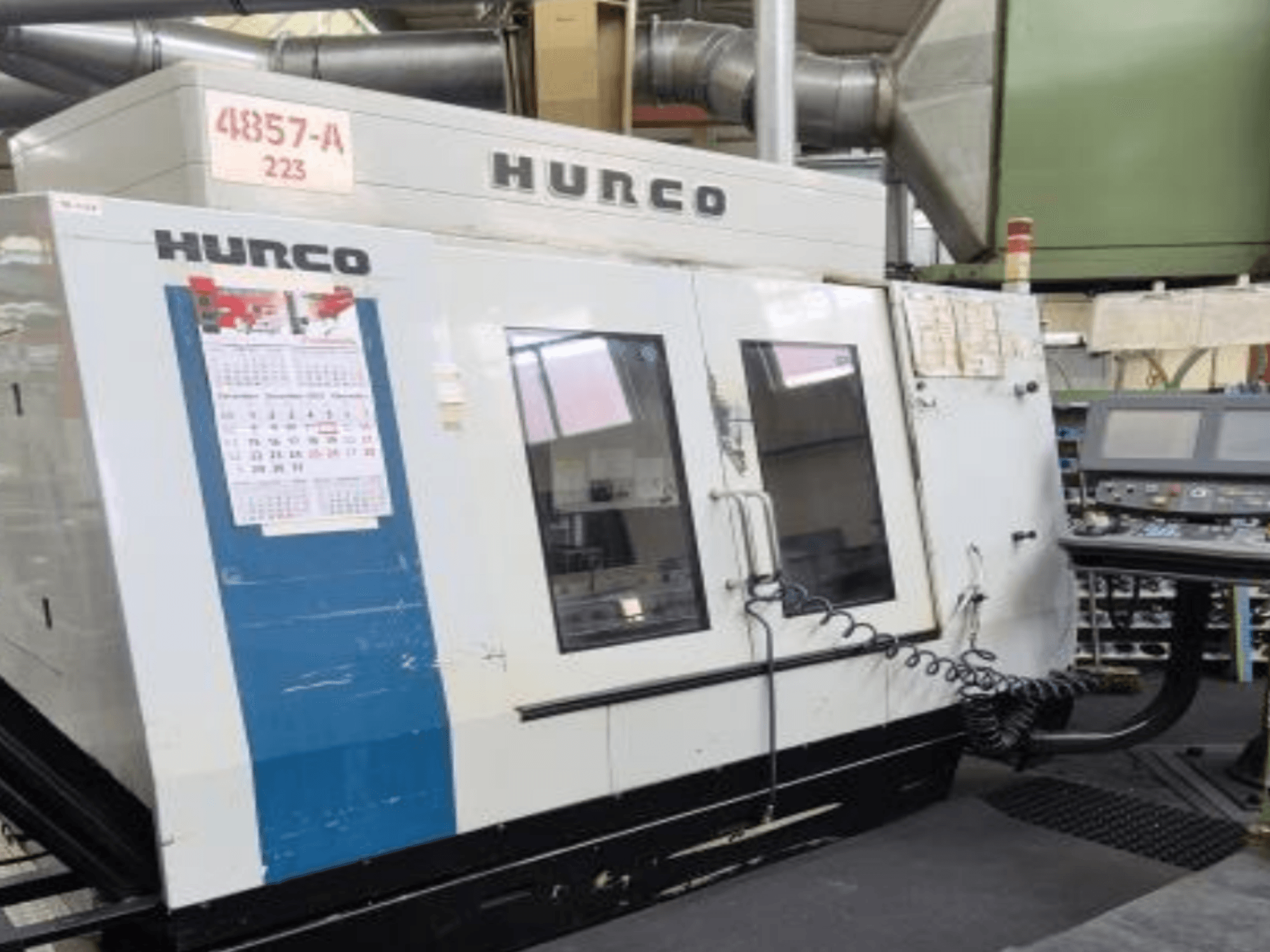 Centro di lavoro verticale Hurco VMX 42 in vista frontale, con pannello di controllo, calendario e dettagli esterni in metallo.