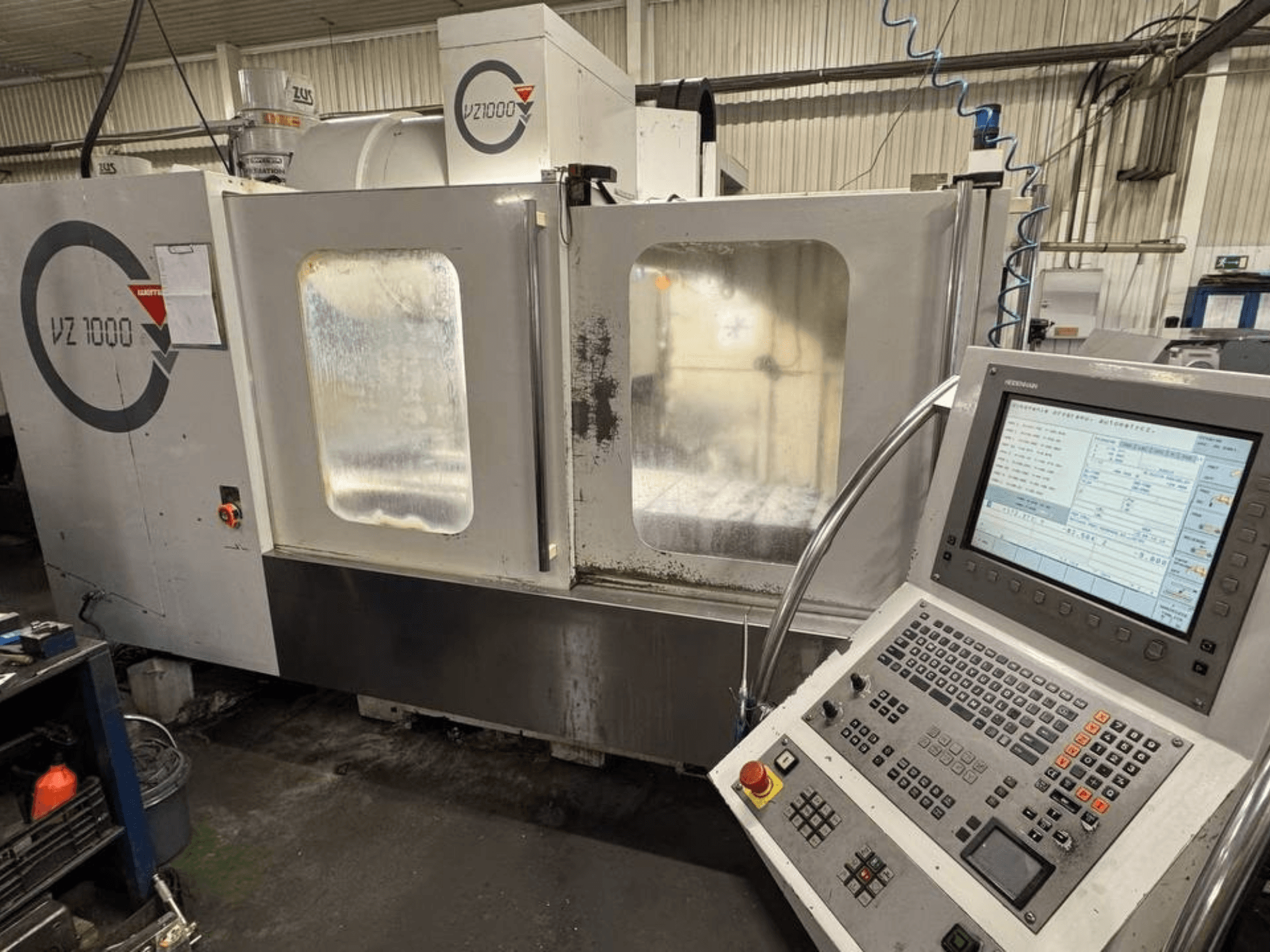 Vista frontale del centro di lavoro verticale WEMAS VZ 1000, con pannello di controllo e porte di accesso trasparenti.