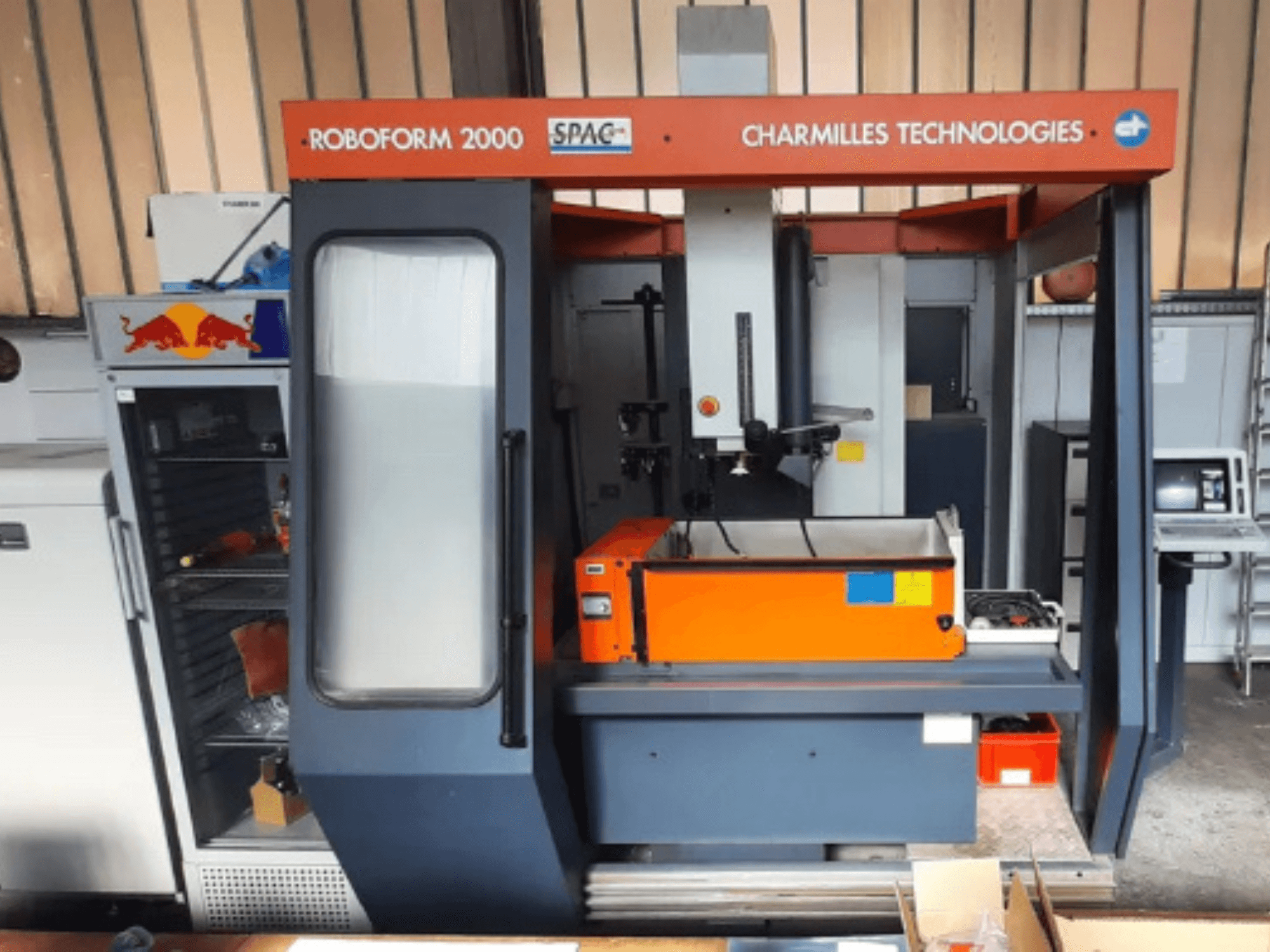 Macchina per elettroerosione a tuffo CHARMILLES Roboform 2000 vista frontale, con piano di lavoro e pannello di controllo di colore arancione.