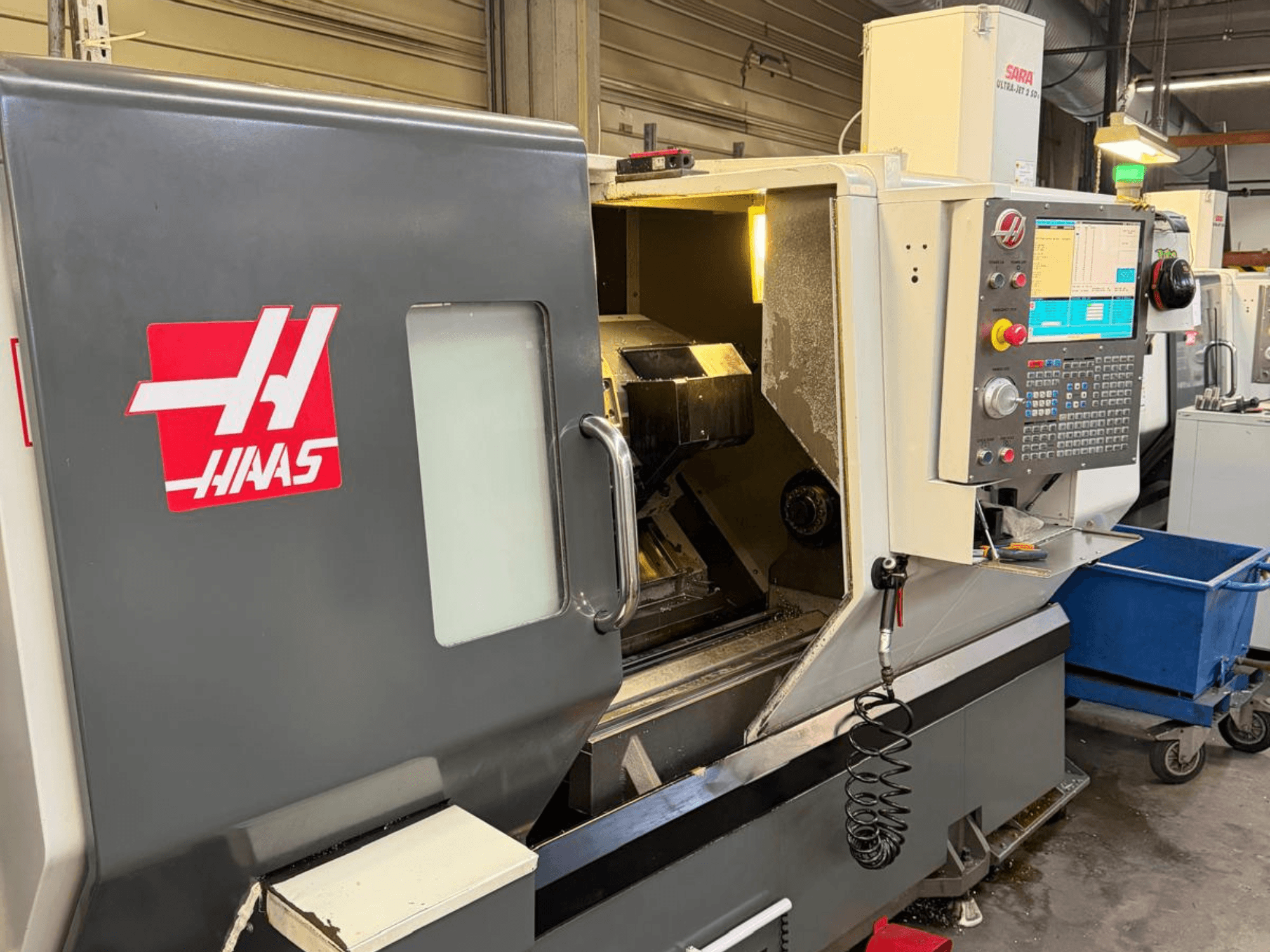 Tornio orizzontale HAAS DS-30SSY, vista frontale, con pannello di controllo e componenti interni visibili, in ambiente d'officina.