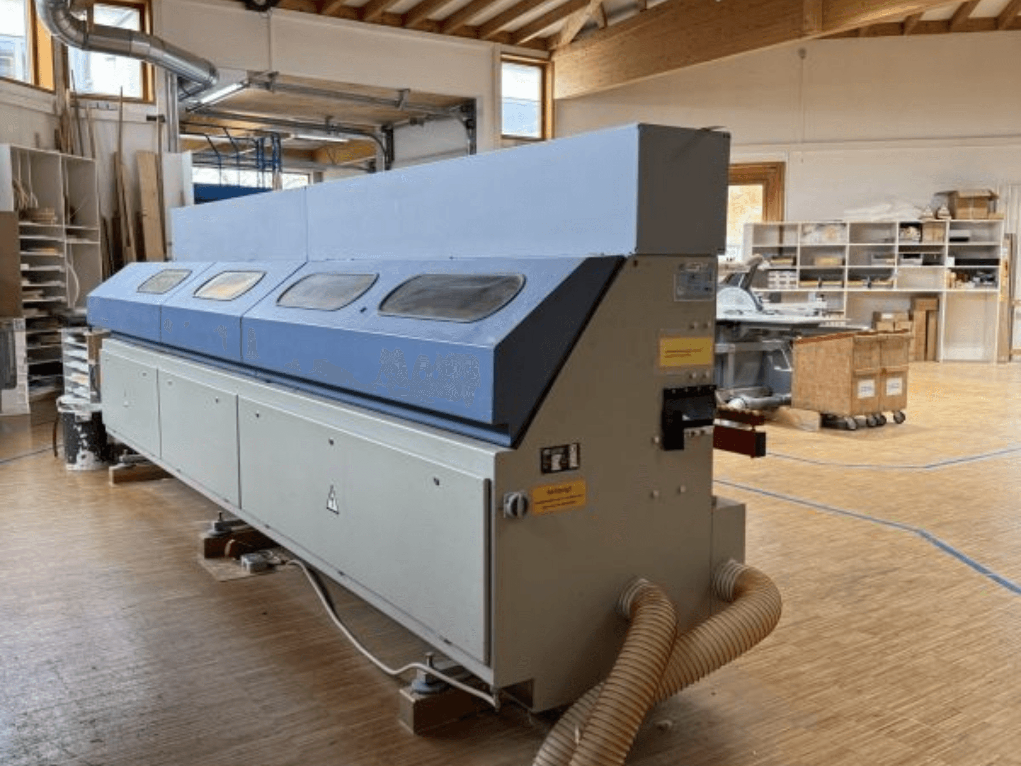 Bordatrice OTT Pacific V6-F vista di lato; presenta un lungo piano blu e un pannello di controllo con attacco per il tubo flessibile.