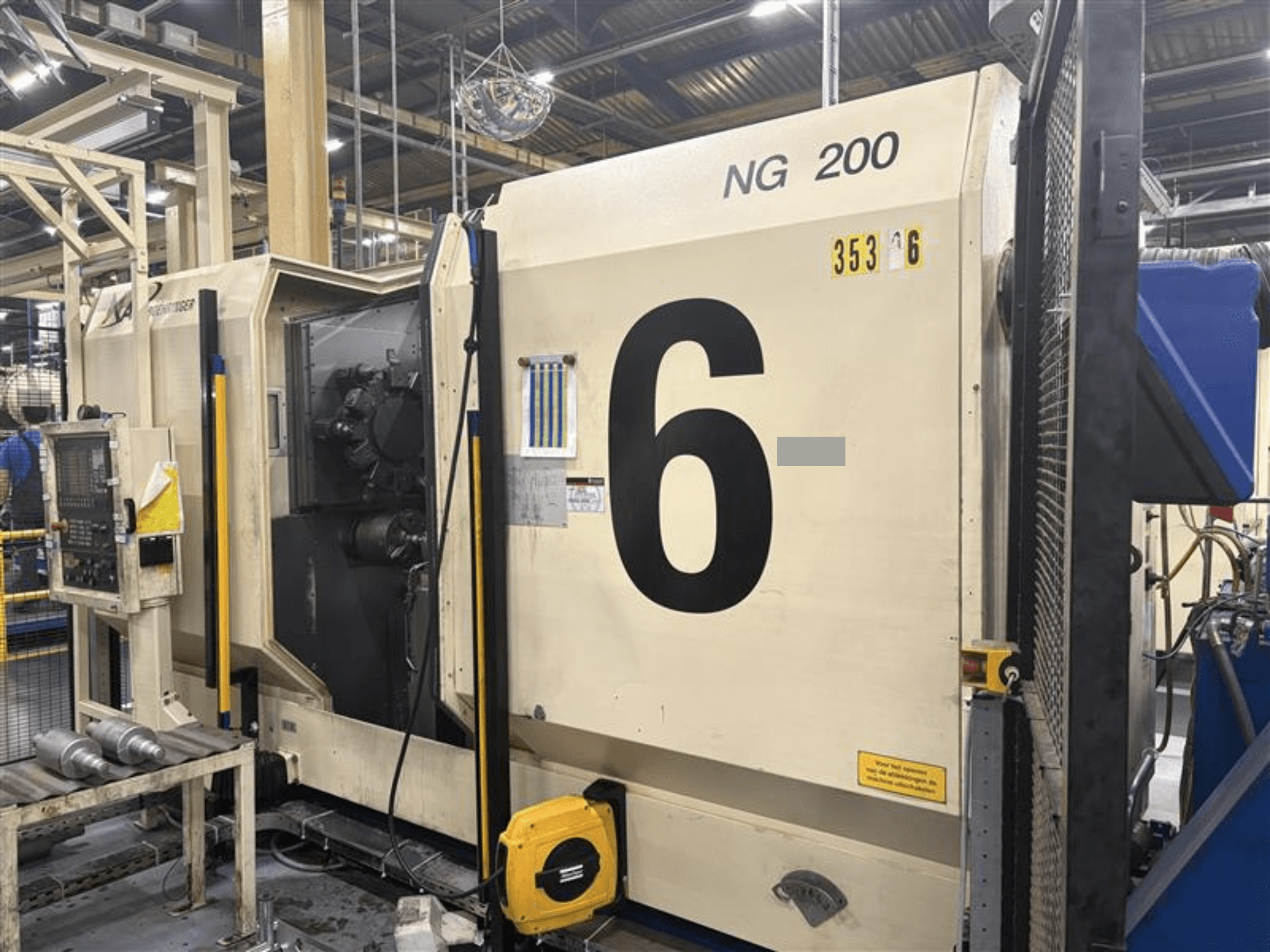 Vista frontale del tornio orizzontale BOEHRINGER NG-200 con grandi numeri e pannello di controllo visibili, in un ambiente di fabbrica.