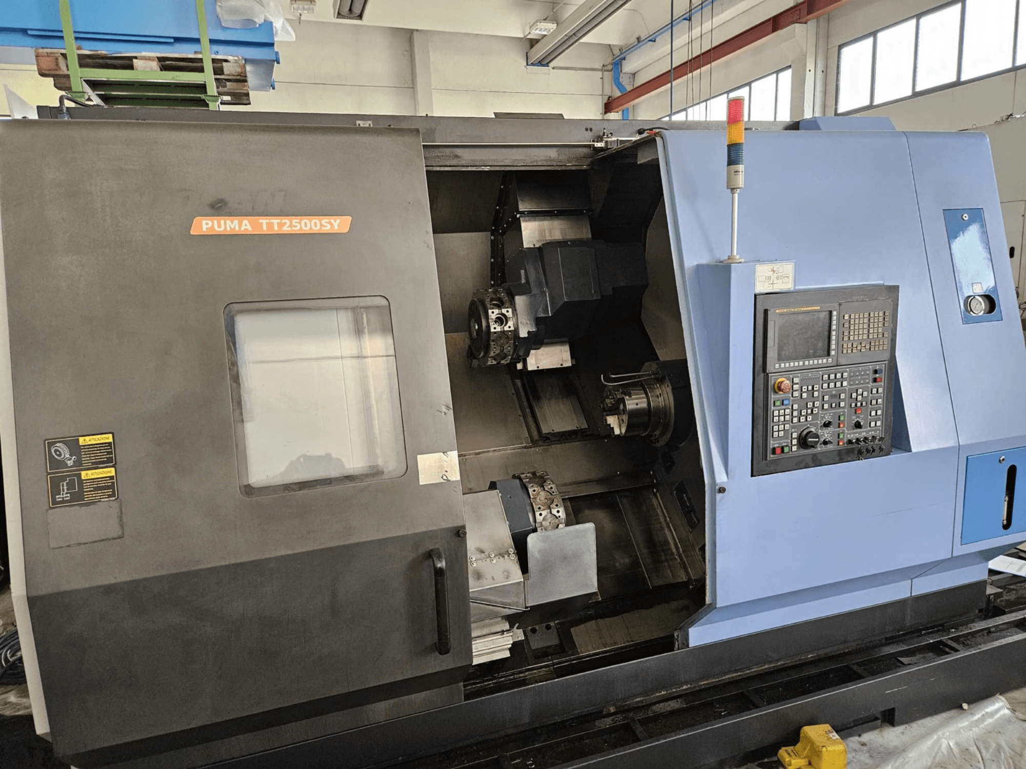 Tornio multimandrino DOOSAN PUMA TT2500SY, vista frontale che mostra il pannello di controllo e i dettagli interni della macchina.