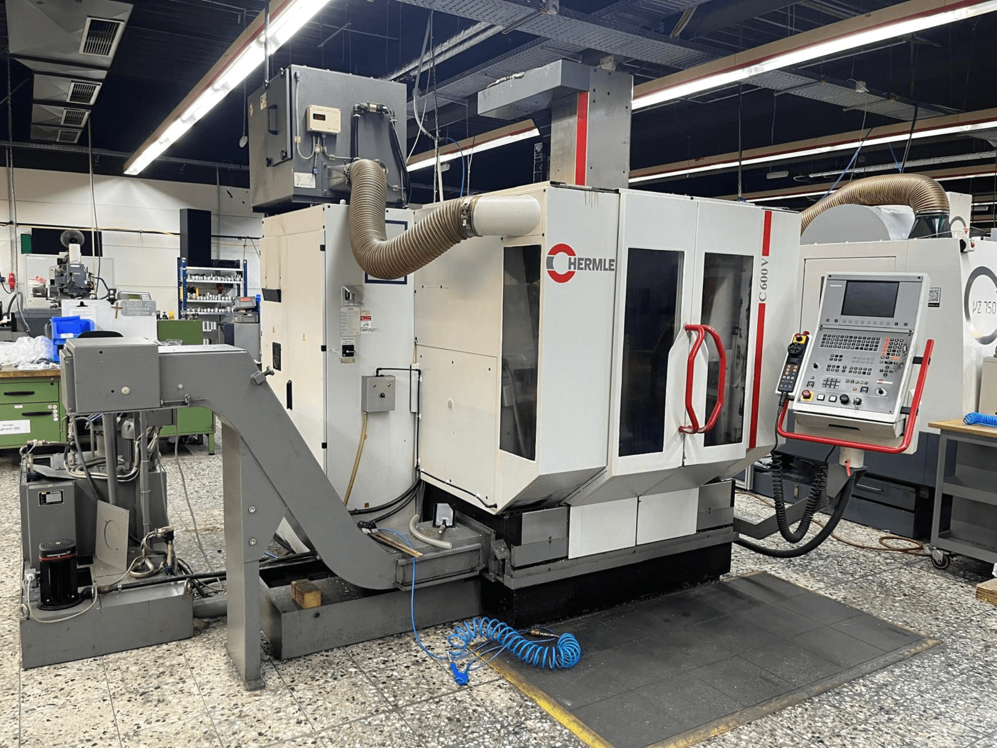Centro di lavoro verticale HERMLE C 600 V in un'officina, vista frontale che mostra il pannello di controllo e le funzioni di ventilazione.