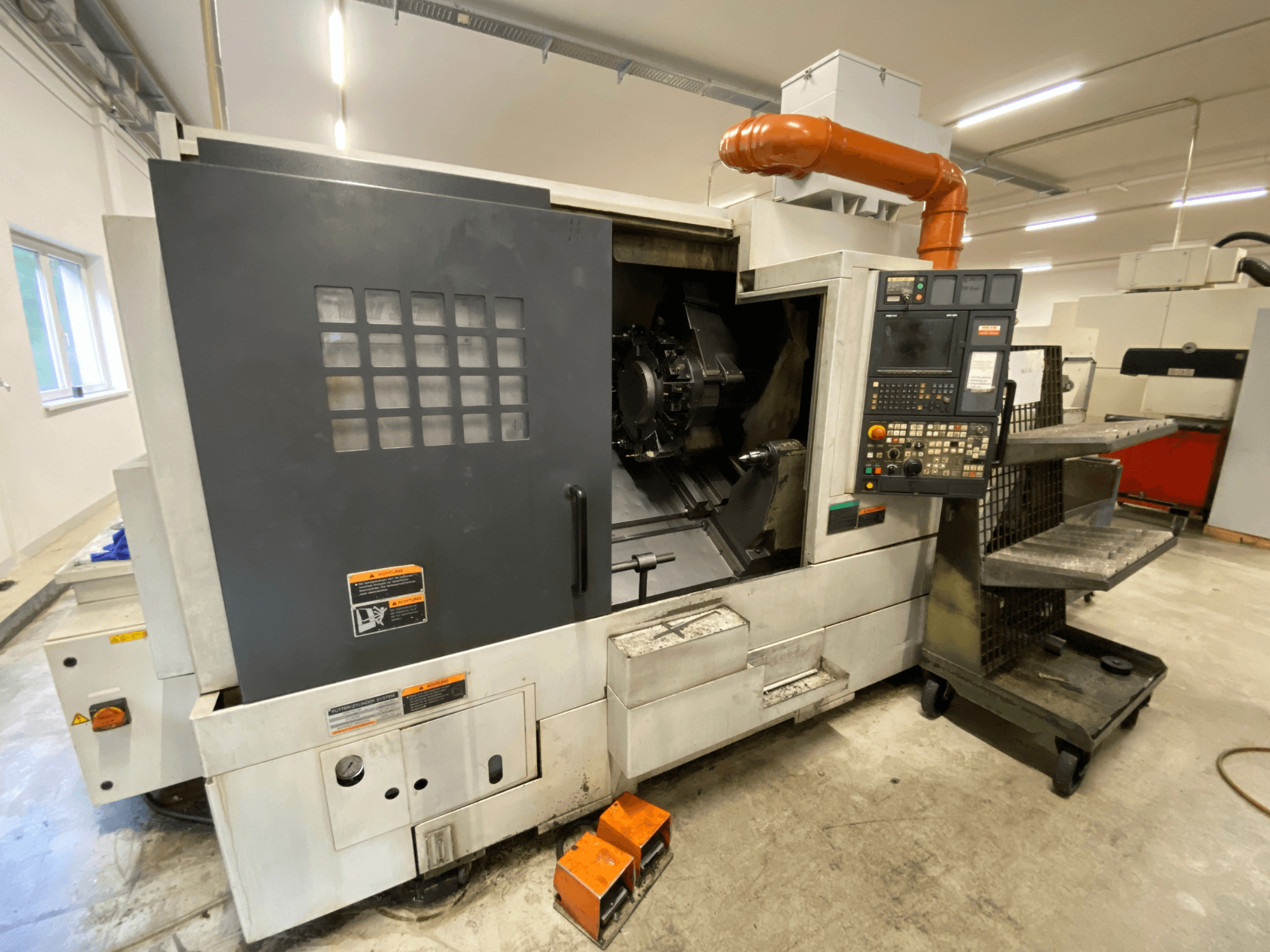 Centro di tornitura e fresatura DMG Mori Seiki NL2500Y/700, vista frontale che mostra il pannello di comando e i dettagli della carenatura della macchina.