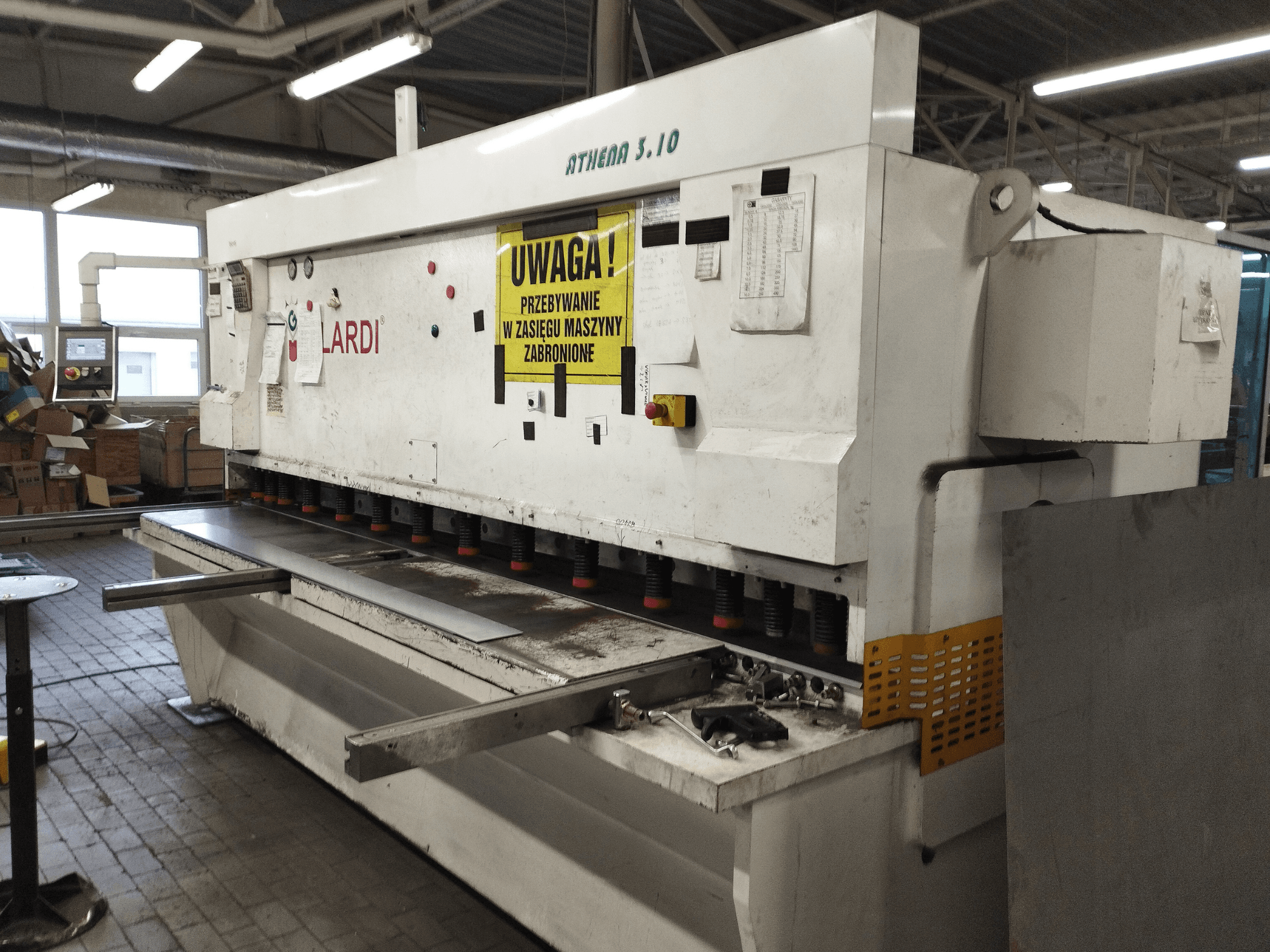 Cesoia CNC GILARDI ATHENA 3.10 in un'officina, vista frontale, con pannello di controllo e lame di taglio.