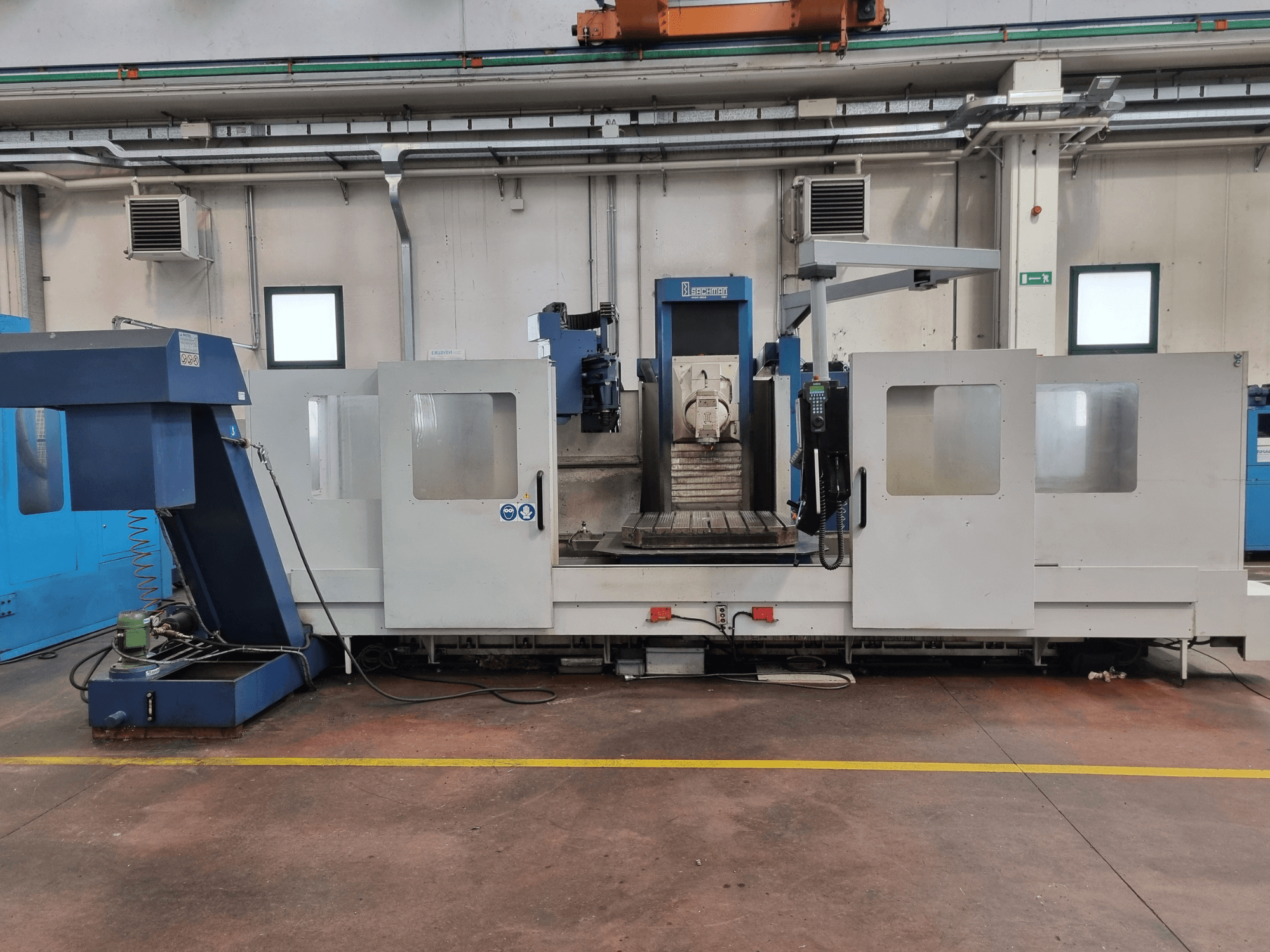 Fresatrice CNC "Brembana", vista laterale che mostra il pannello di controllo e l'area operativa con il tavolo di lavoro all'interno.