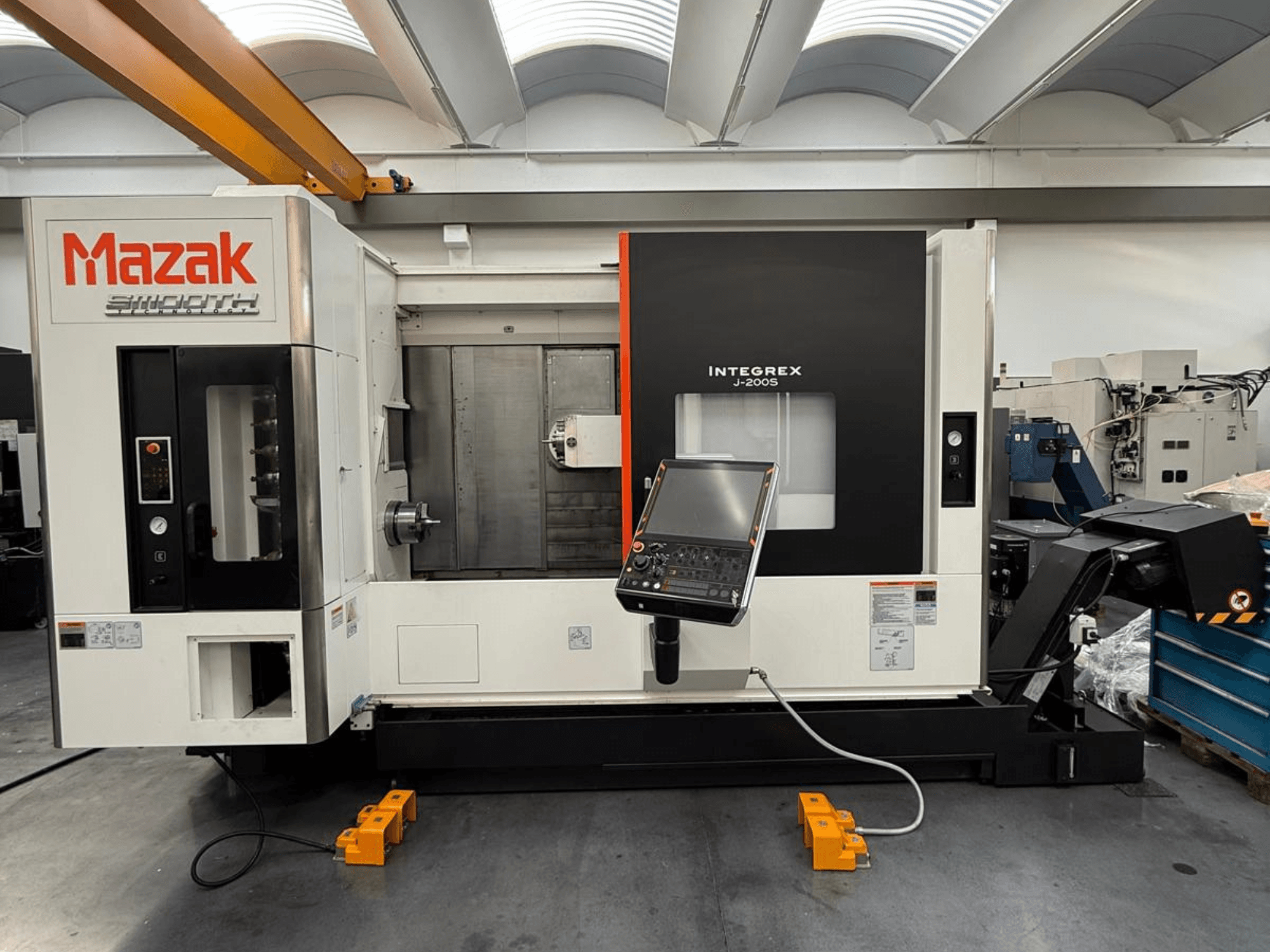 Centro di fresatura-tornitura Mazak INTEGREX J-200 S in vista frontale, con pannello di controllo e area di lavorazione, sul pavimento della fabbrica.