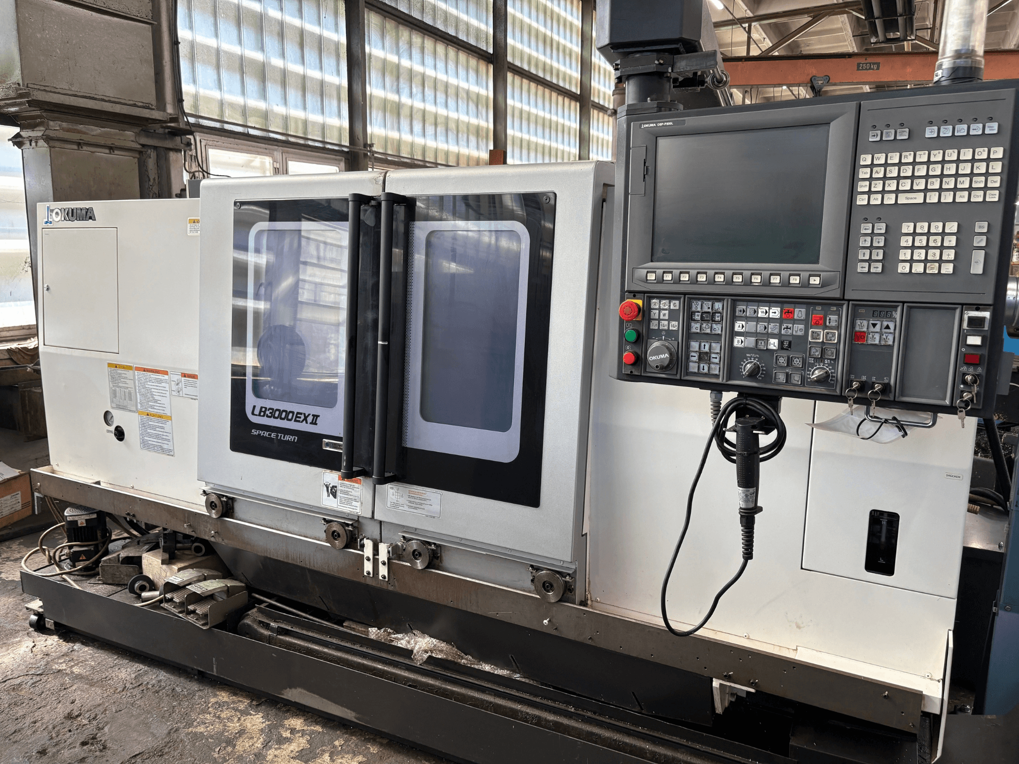 Tornio orizzontale Okuma LB3000EXII, vista frontale che mostra il pannello di controllo e lo sportello di carico.