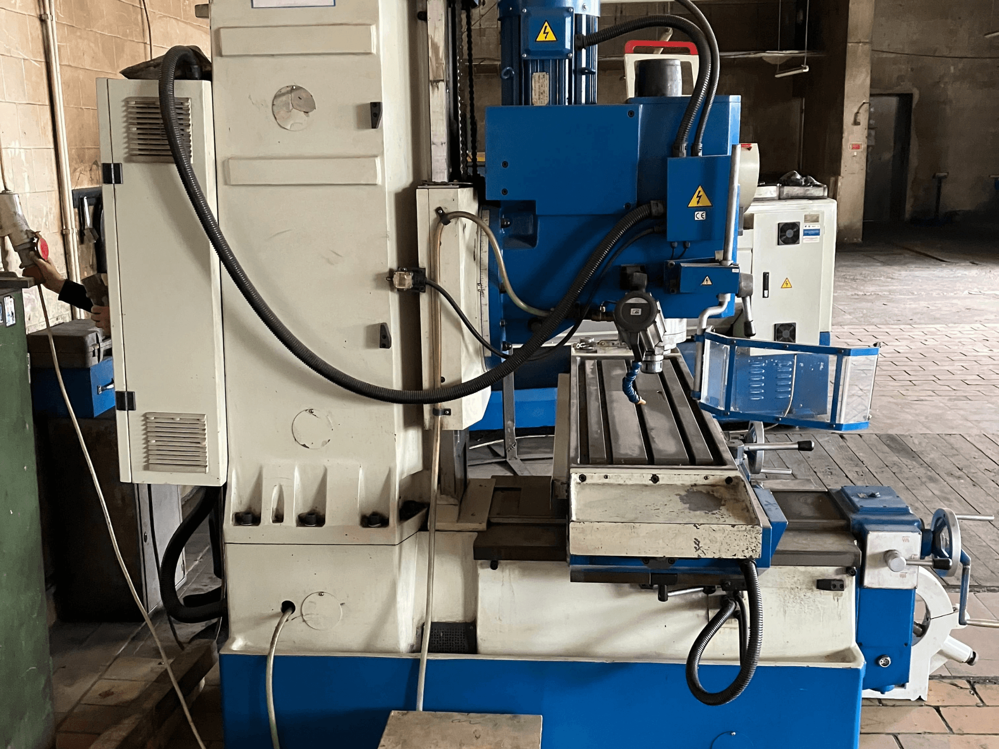 Centro di lavorazione verticale KNUTH KB 1400, vista frontale che mostra il pannello di controllo, l'utensile da taglio e il piano di lavoro con guide lineari.