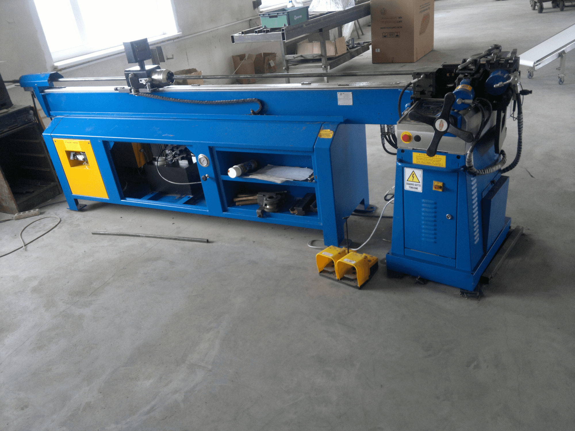 Macchina per la lavorazione del legno blu con accenti gialli, vista laterale; dispone di pannello di controllo, pedali e gruppo lama rotante.