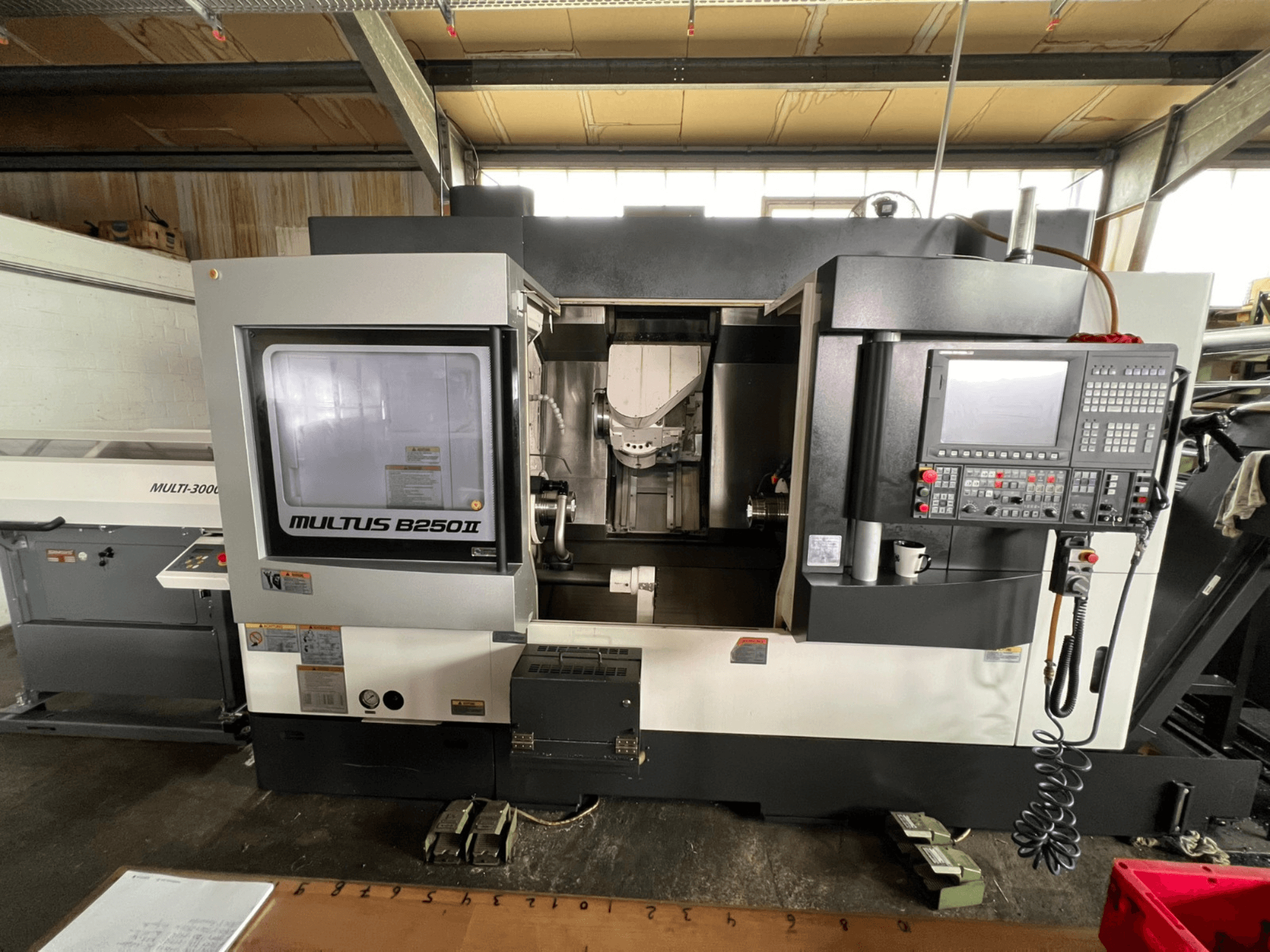 Centro di tornitura-fresatura Okuma Multus B250II MW, vista frontale, con dettagli del pannello di controllo e dell'area di lavorazione.
