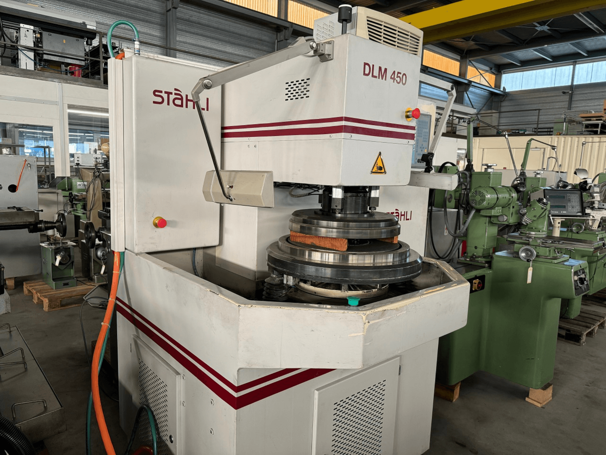 Rettificatrice piana STAEHLI DLM 450, vista frontale con mola e pannello di comando, in un ambiente industriale.