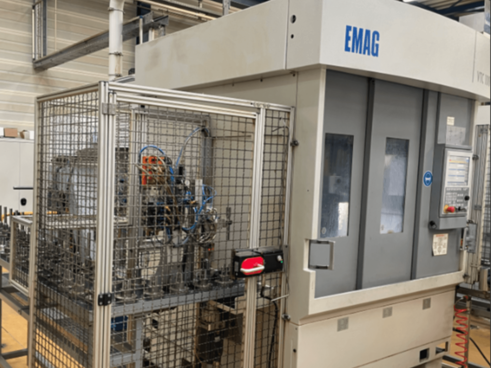 Tornio verticale EMAG VTC 100 visto di lato, con particolare attenzione al pannello di controllo e alle recinzioni di sicurezza.