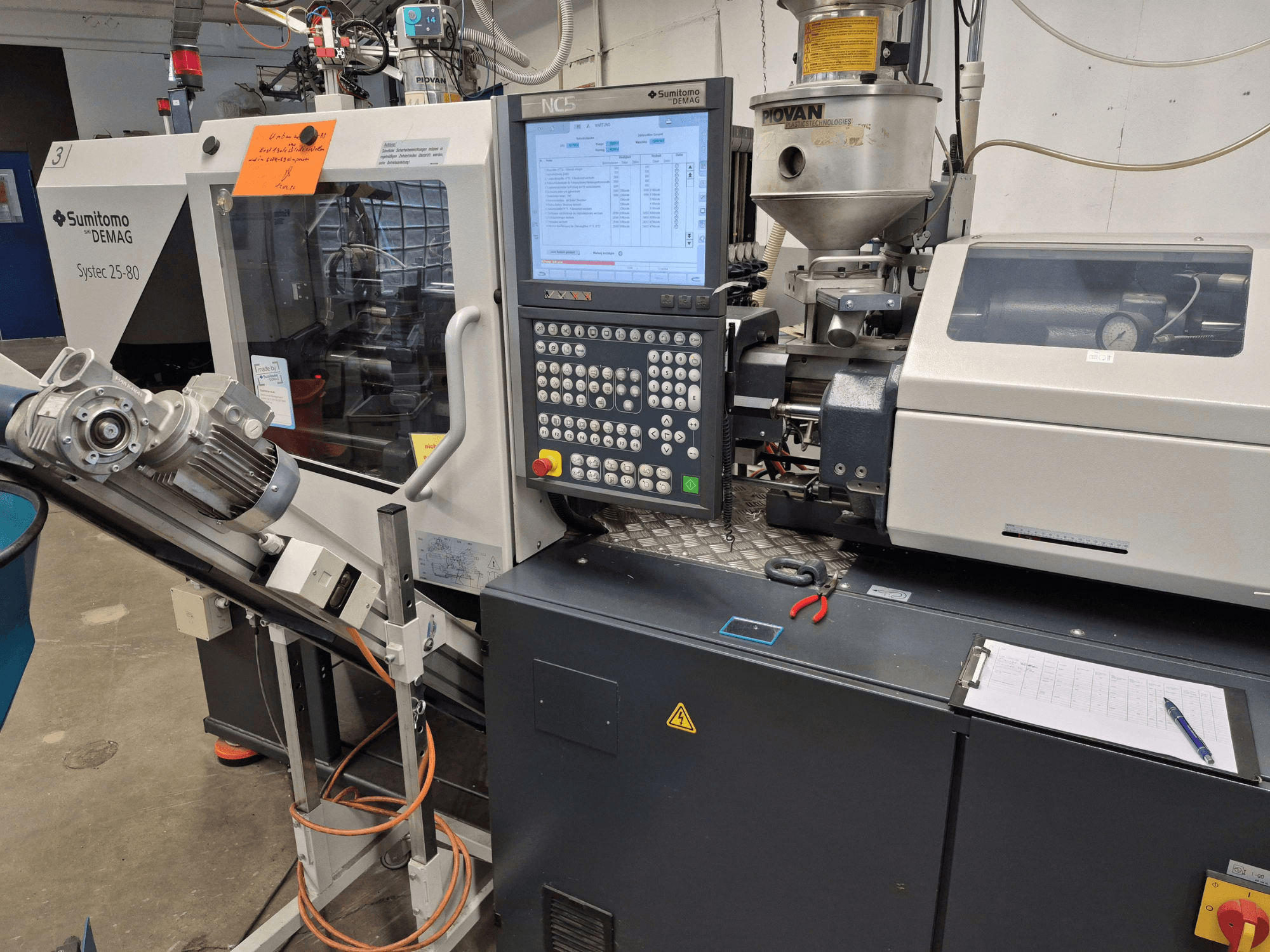 Macchina per stampaggio a iniezione idraulica SUMITOMO SHI DEMAG Systec 25/320-80, vista frontale con pannello di controllo e sistema di alimentazione in primo piano.