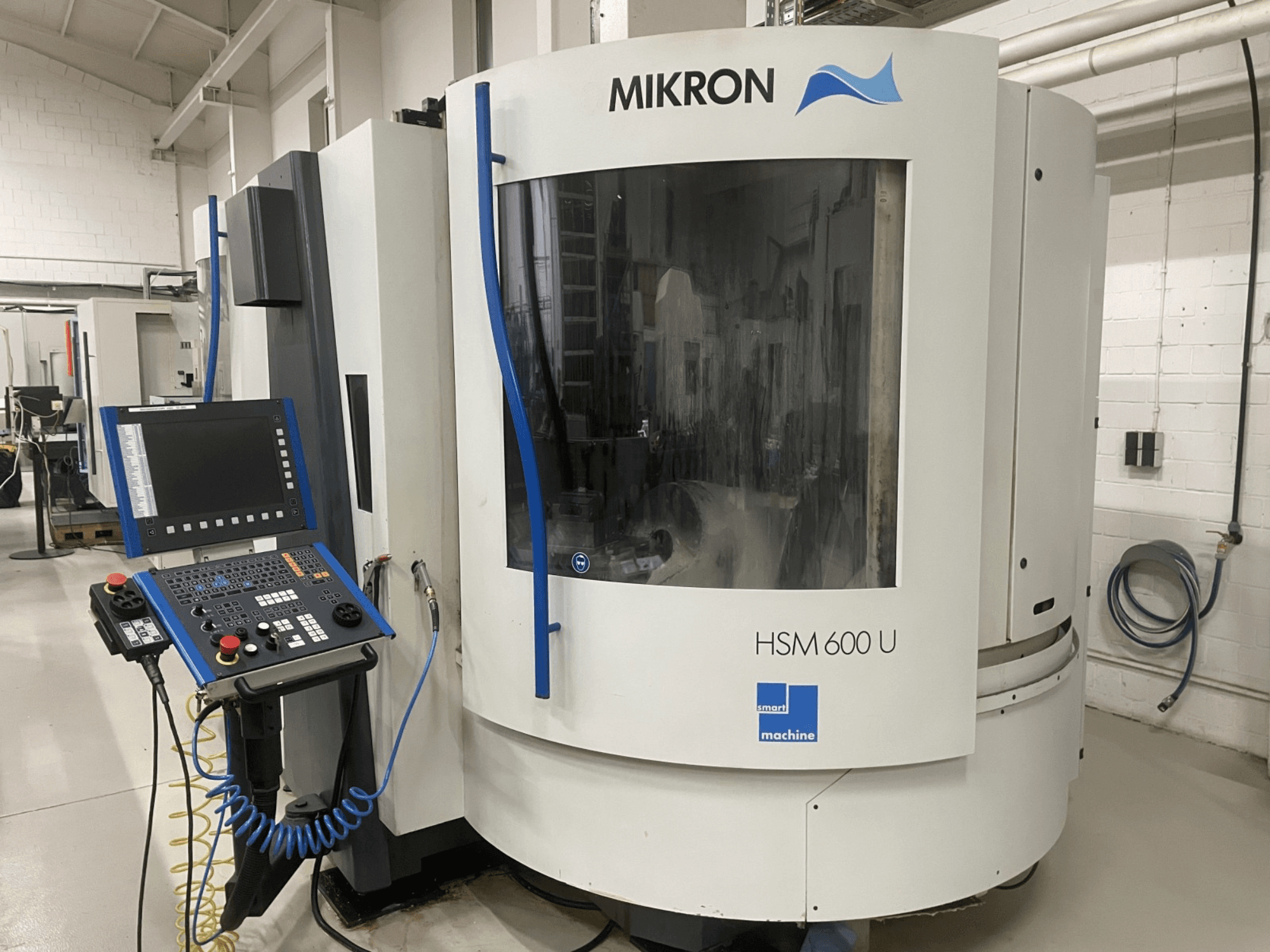 Centro di lavoro verticale MIKRON HSM600U visto frontalmente, con pannello di controllo operativo e ampia finestra di visualizzazione.