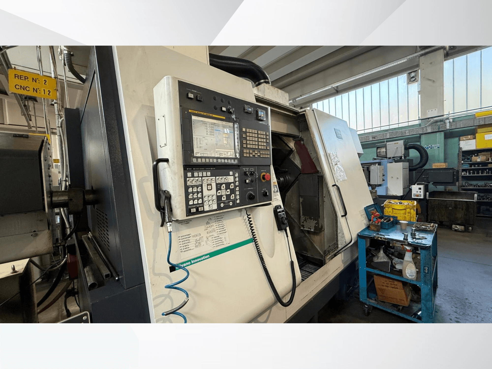 Tornio orizzontale Miyano ABX64 YY2 vista frontale, con pannello di controllo, con utensili e attrezzature in un'officina.