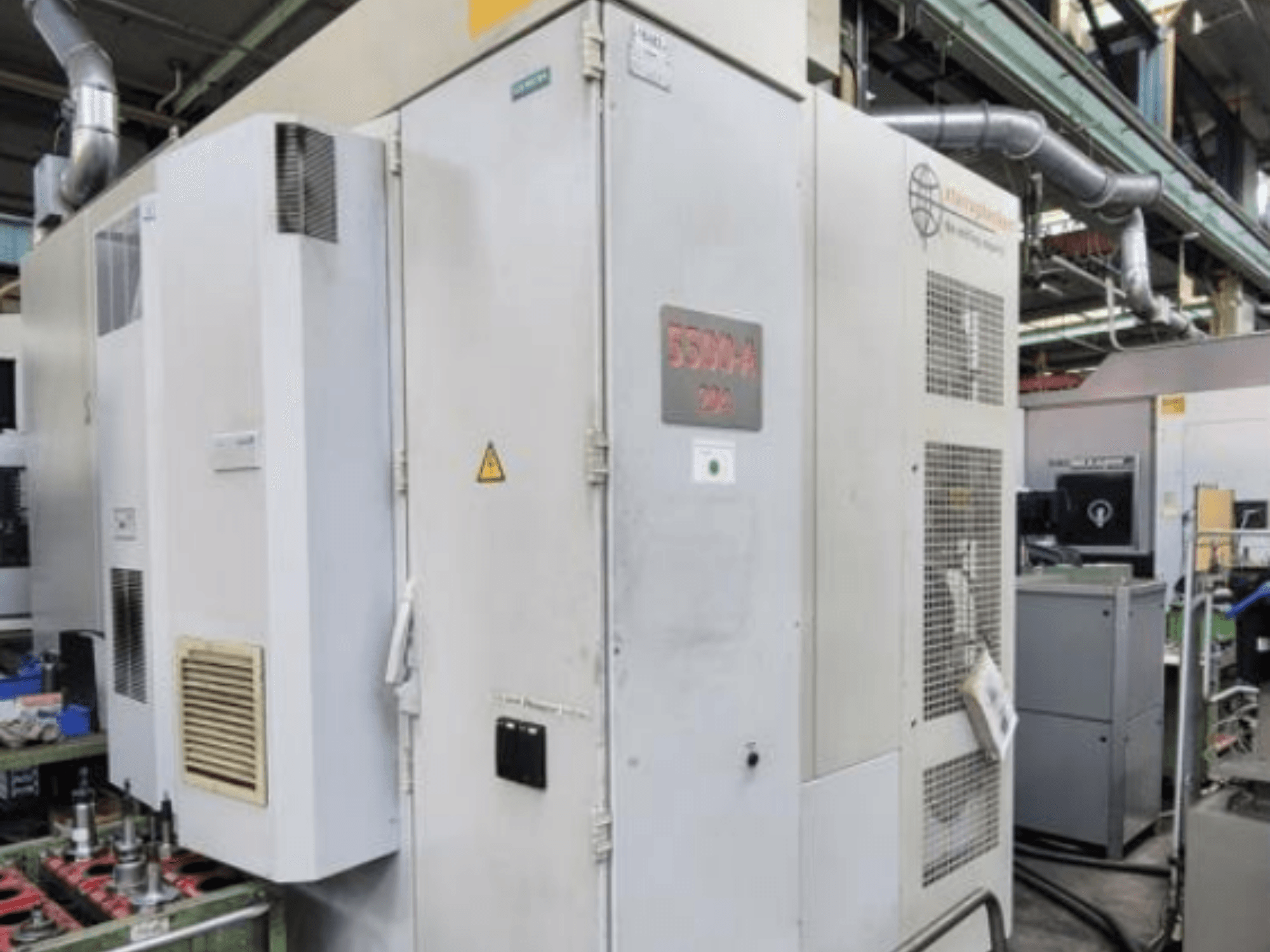 Centro di lavoro orizzontale Starrag Heckert HEC 500 H/V, vista laterale che mostra l'esterno con le bocchette e la segnaletica di avvertimento.