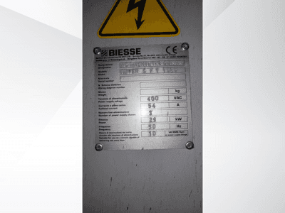 Targhetta delle specifiche tecniche del centro di lavoro a controllo numerico Biesse, con dettagli su tensione, peso e potenza, vista laterale.