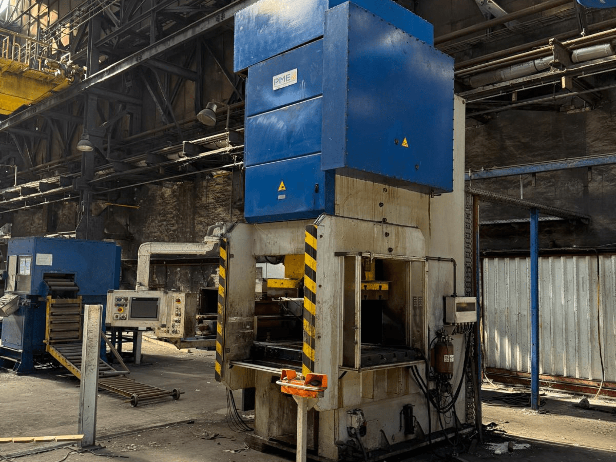 Pressa meccanica per stampaggio PME PE 400-1700 C, vista frontale, che mostra la parte superiore blu e la base a strisce gialle in un ambiente industriale.