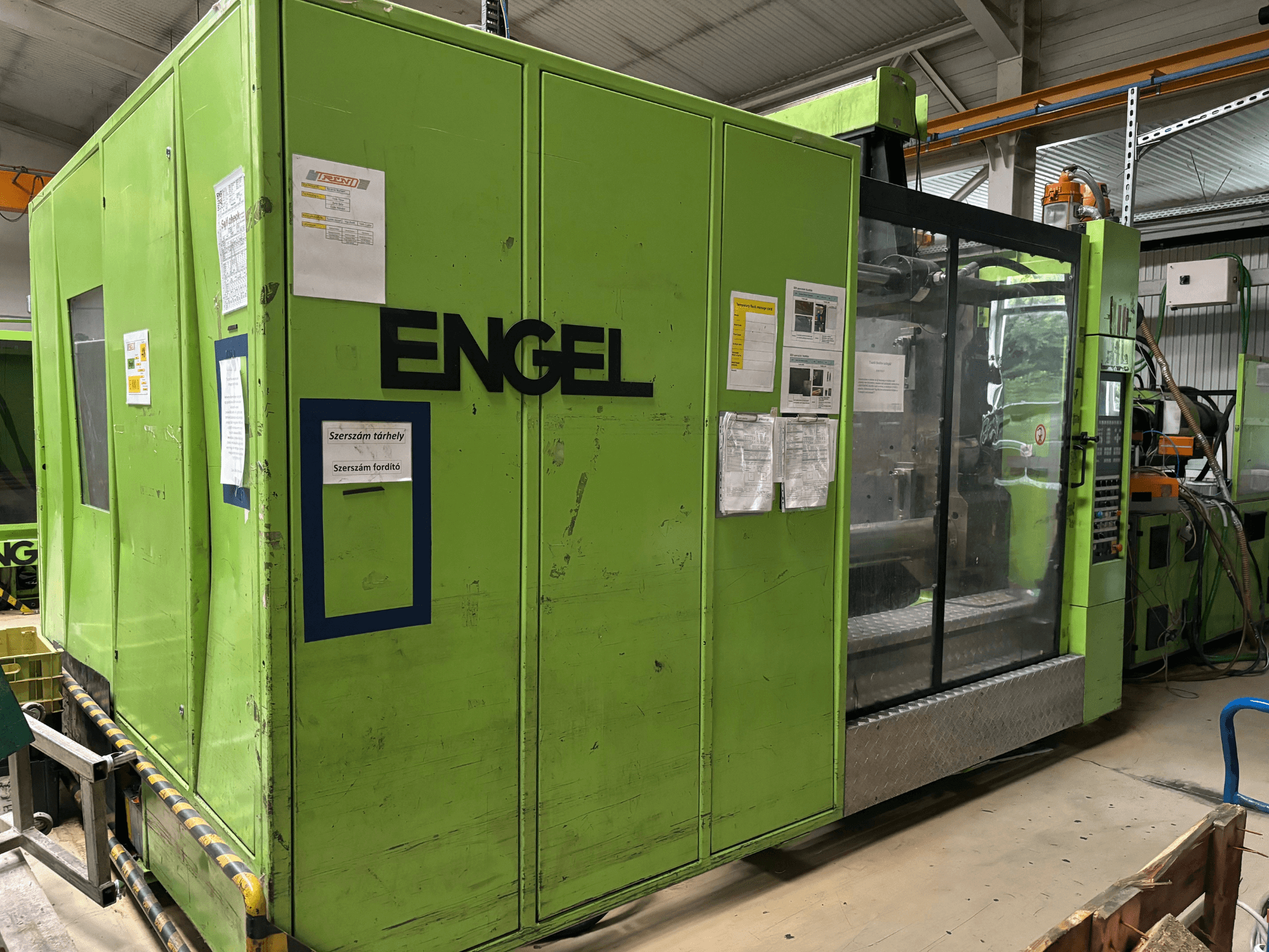 Pressa a iniezione idraulica Engel DUO 5550/800, vista frontale, con esterno verde e pannello di accesso trasparente.