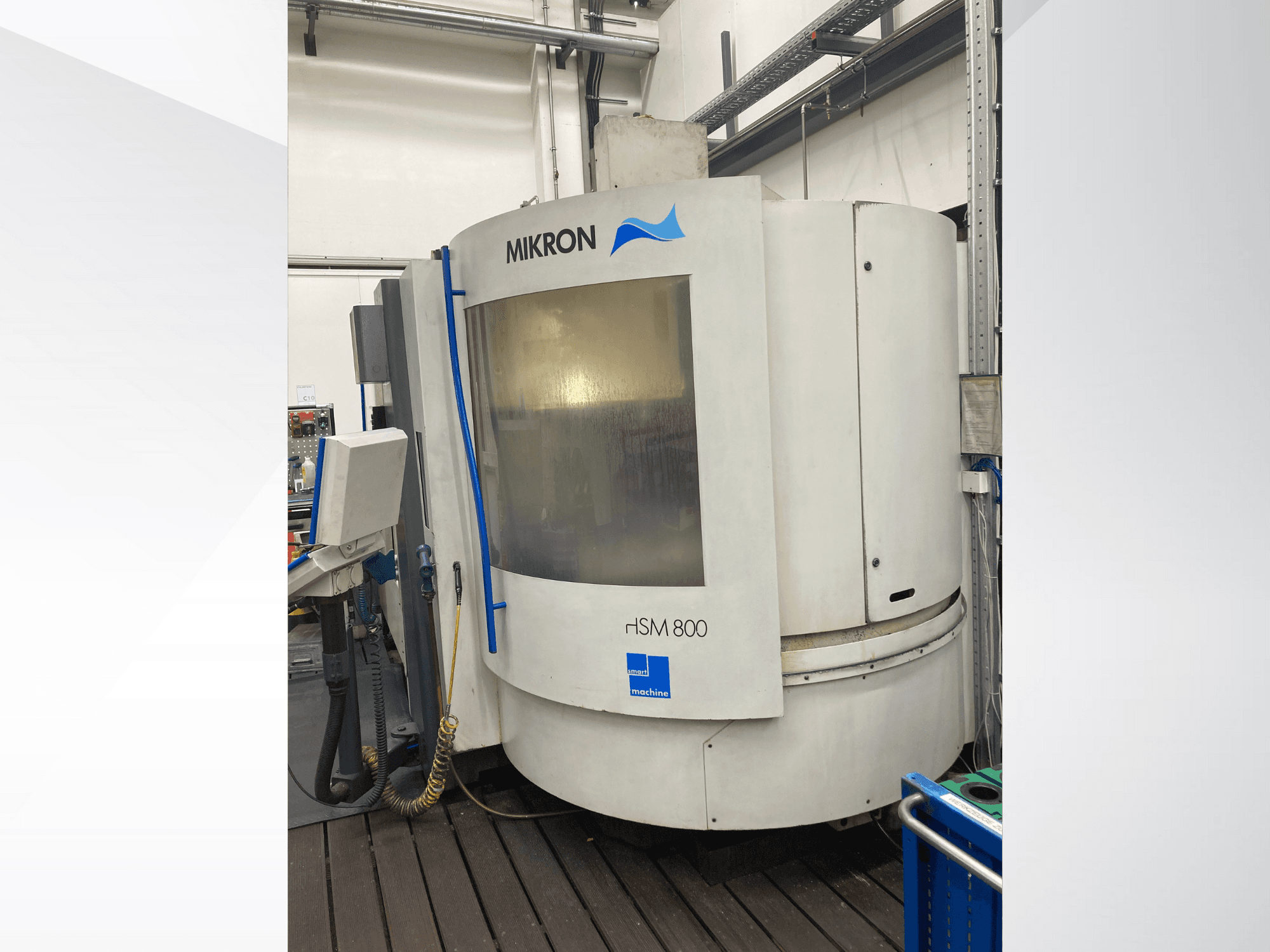 Macchina CNC Mikron rISM 800, vista frontale con pannello di controllo, design cilindrico e accenti blu, ambientata in un'officina.